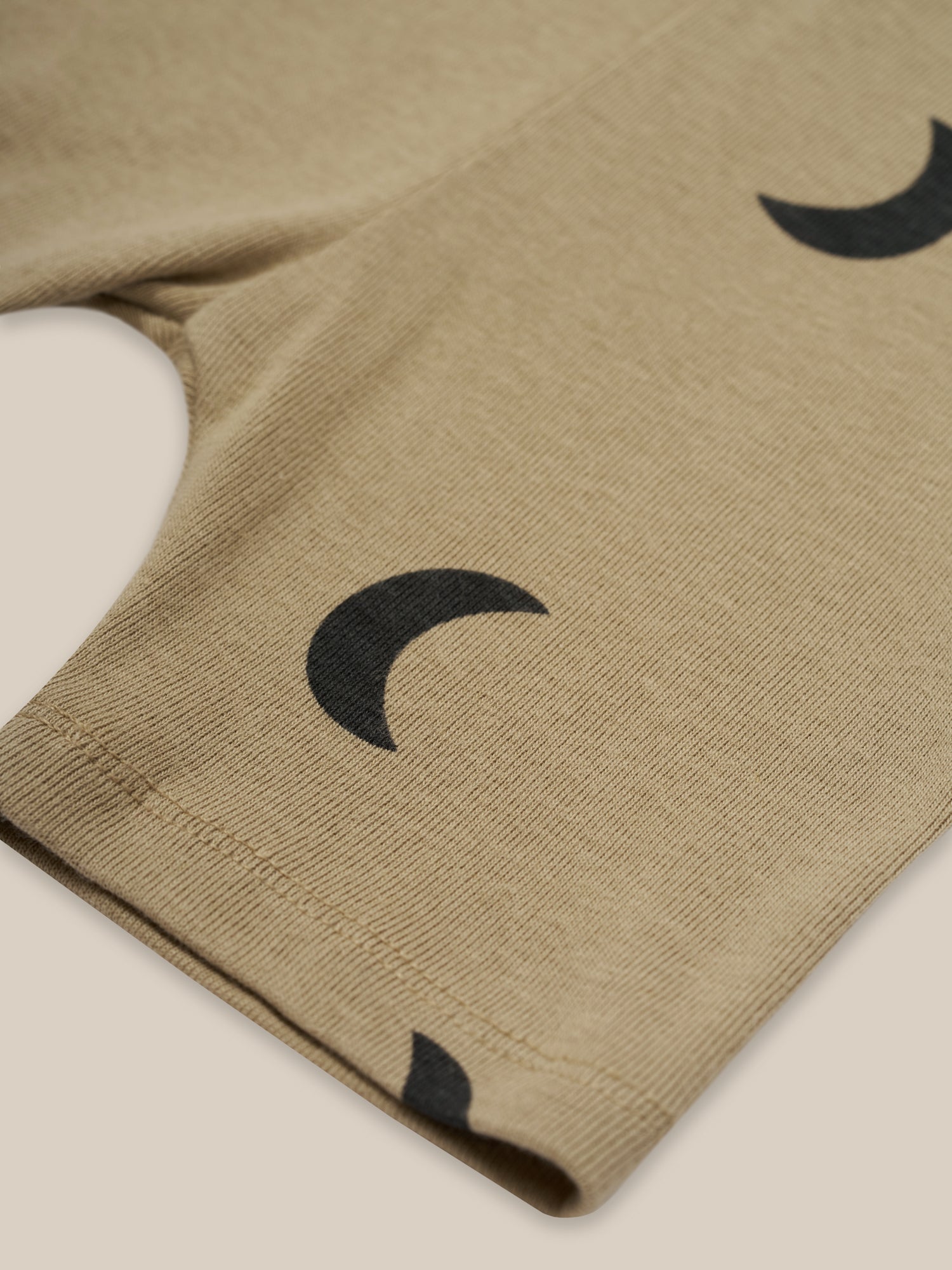 close up of toddler dusky beige organic ribbed cotton biker shorts with black crescents