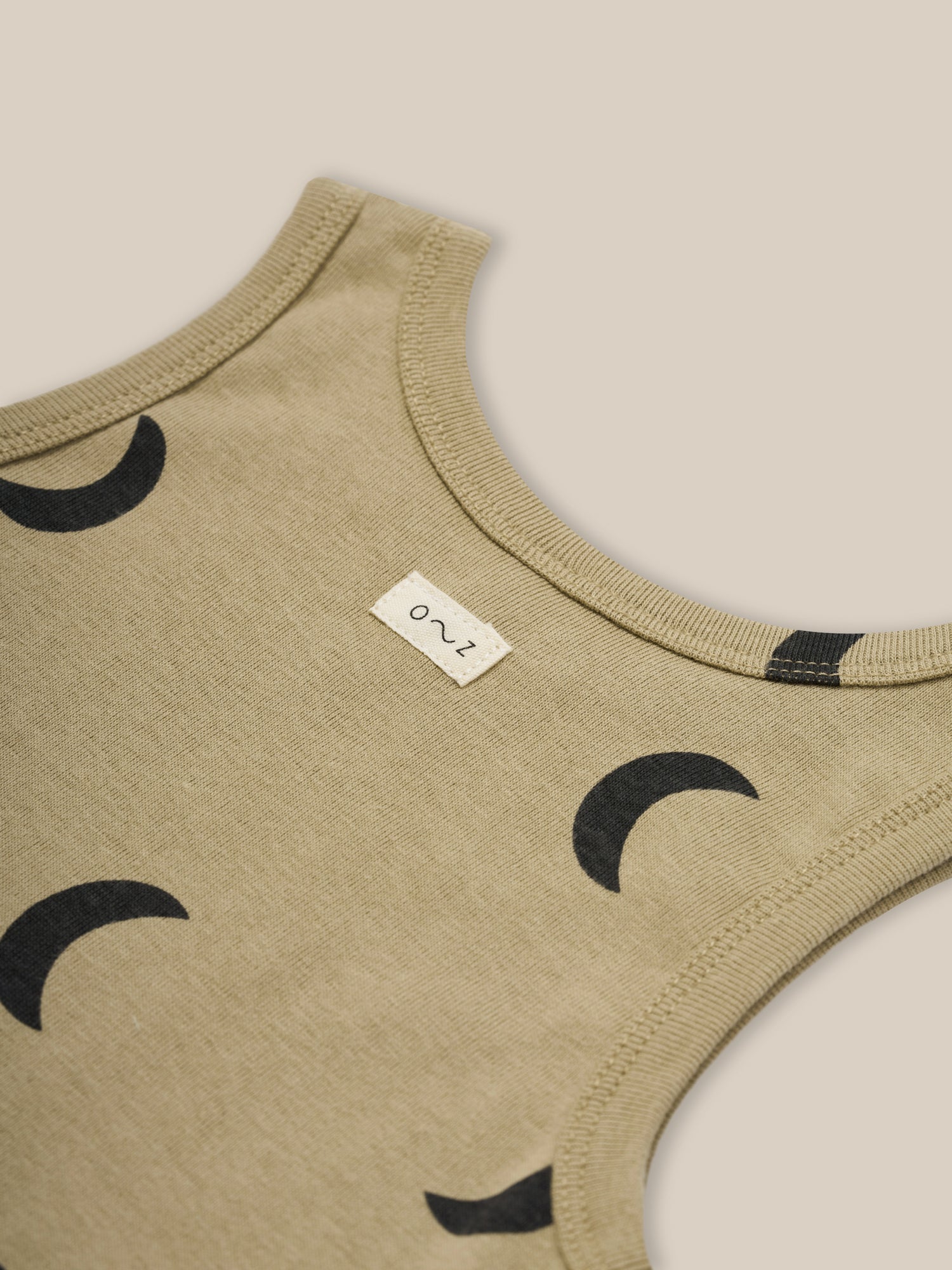 close up of baby and toddler dusky beige organic ribbed cotton summer vest with black moon print