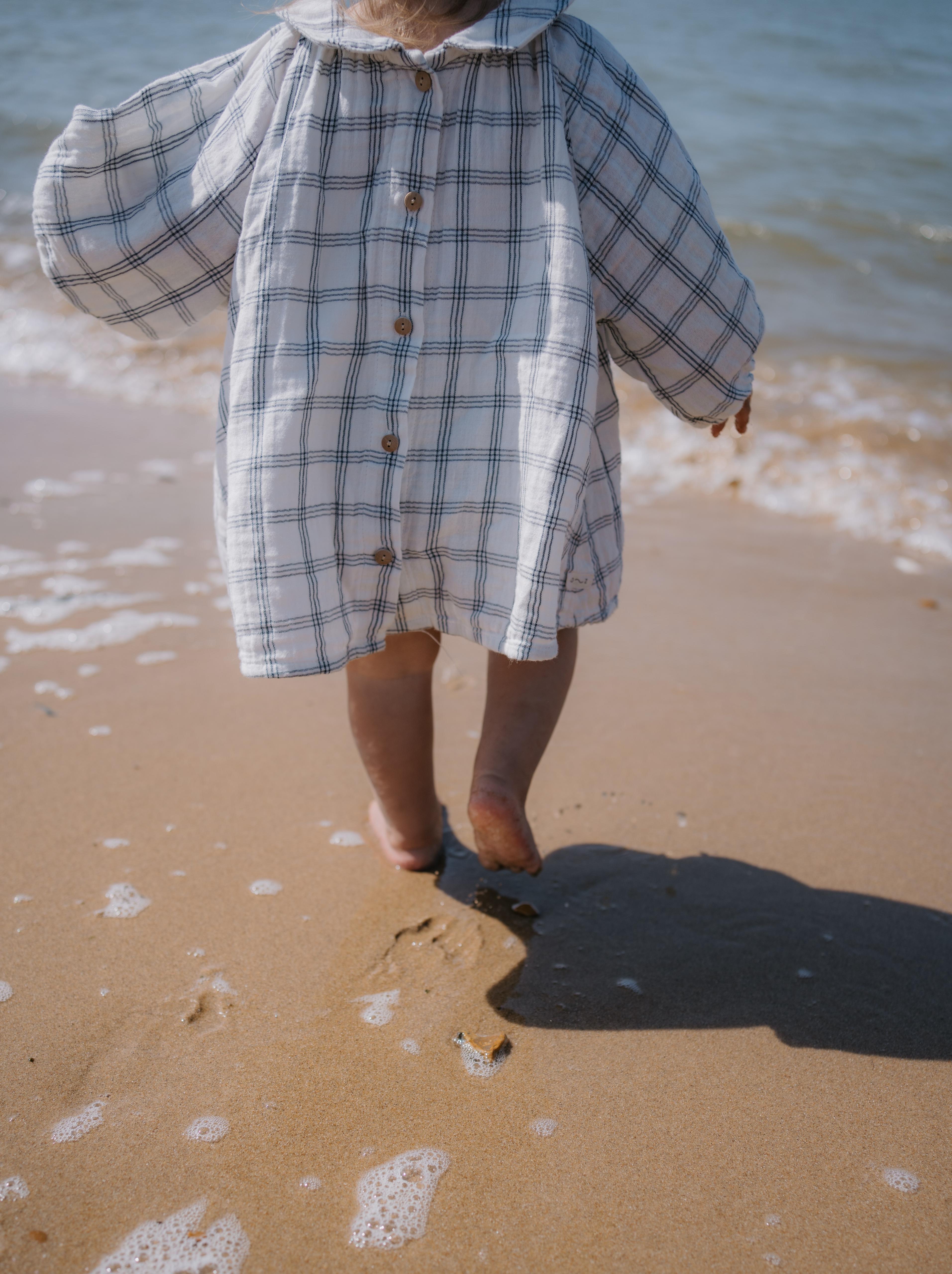 back side of navy window check long sleeved muslin button-down white dress, with peter pan collar & gathered cuffs
