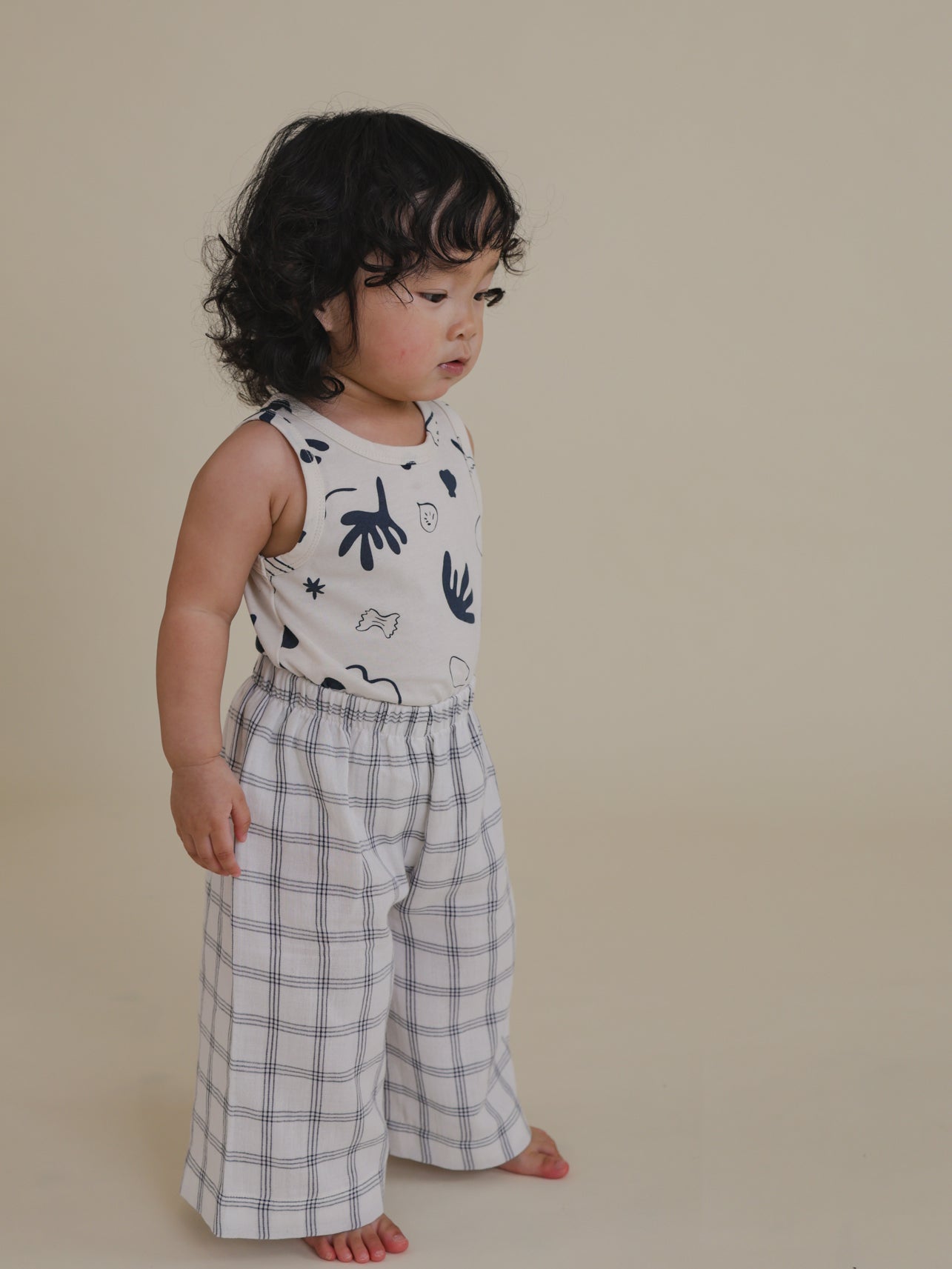 toddler in white muslin wide leg trousers with navy window check print & elasticated waist