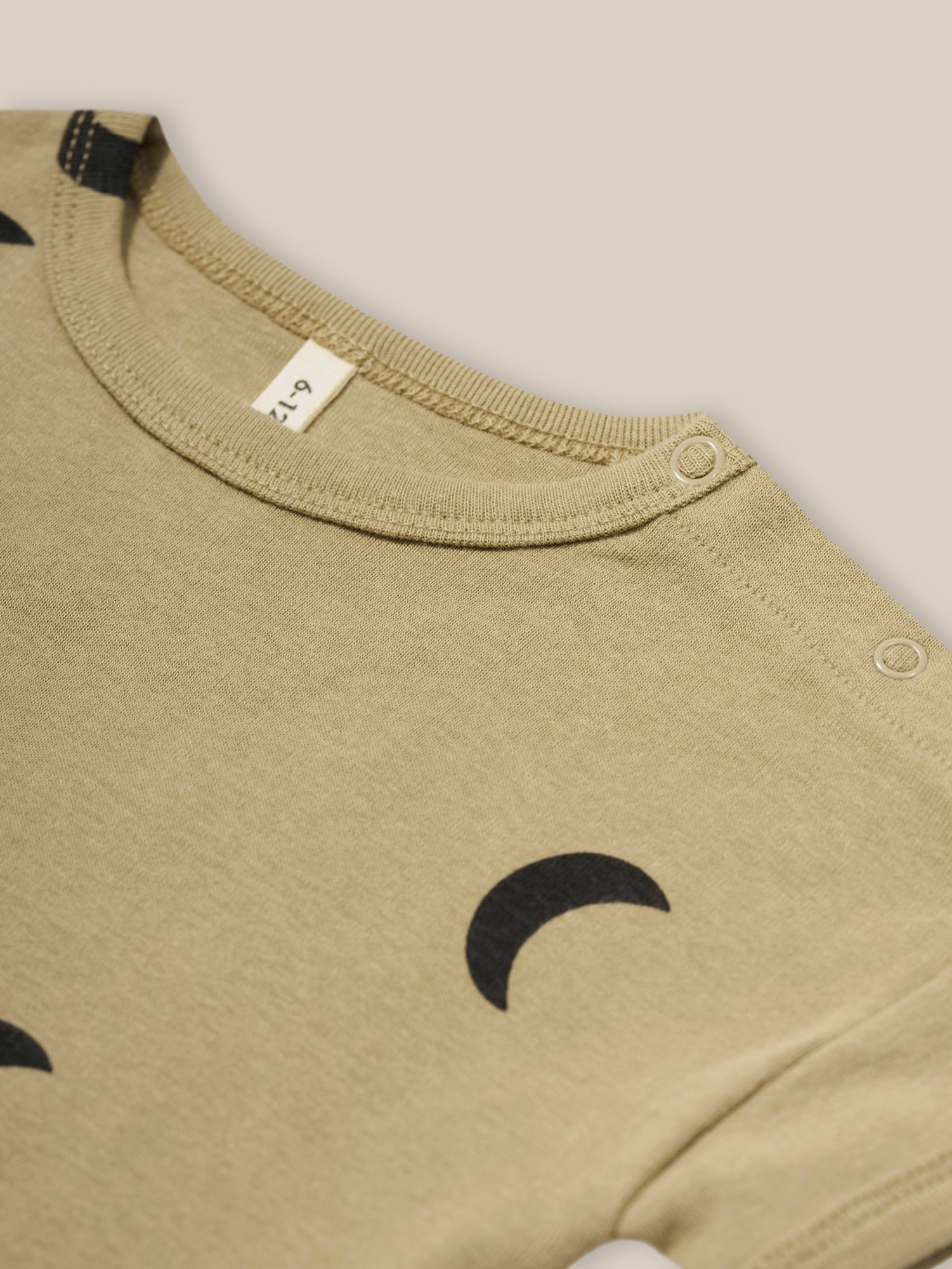 close up of baby dusky beige organic ribbed cotton boxy drop shoulder t-shirt with shoulder poppers