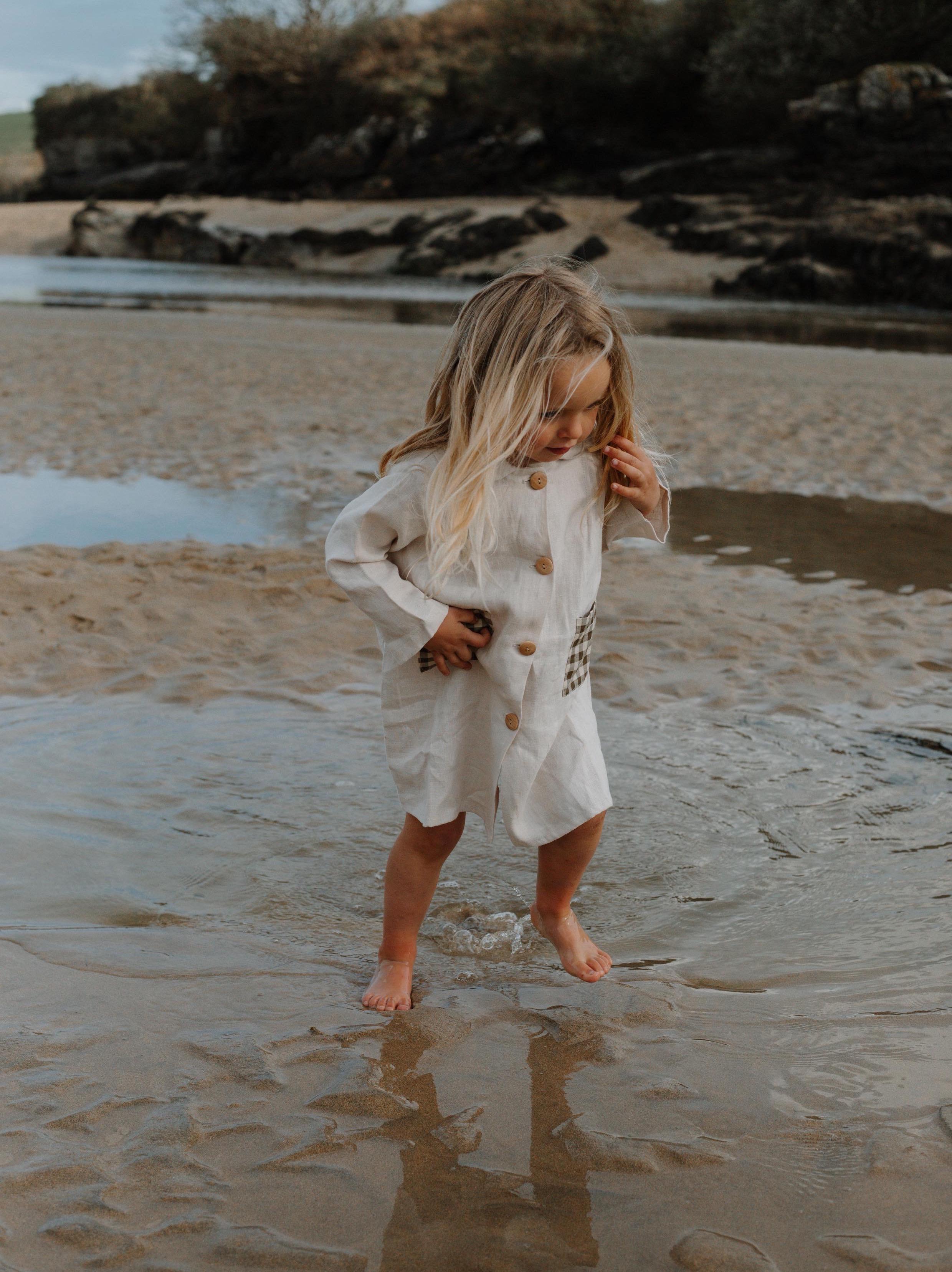Girl on the beach wearing ceramic white linien potter dress