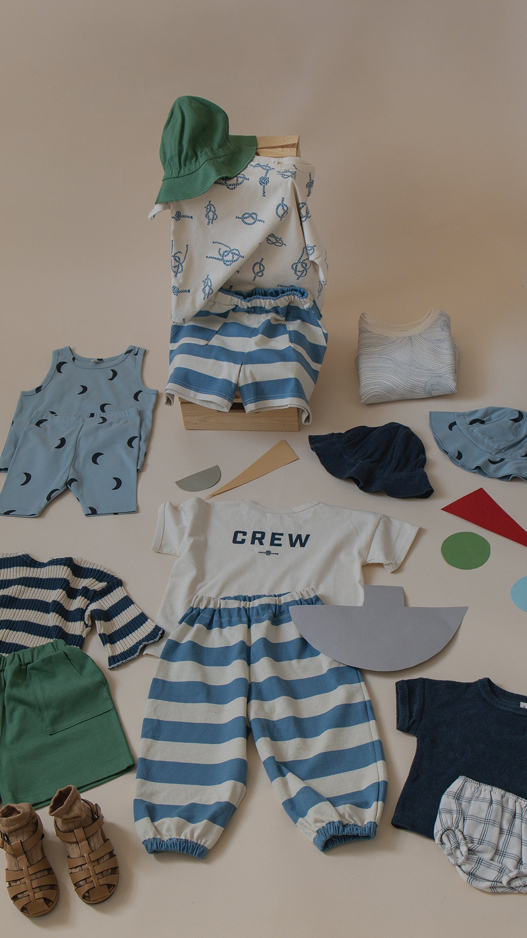 Collection of children's clothing and accessories on a neutral background