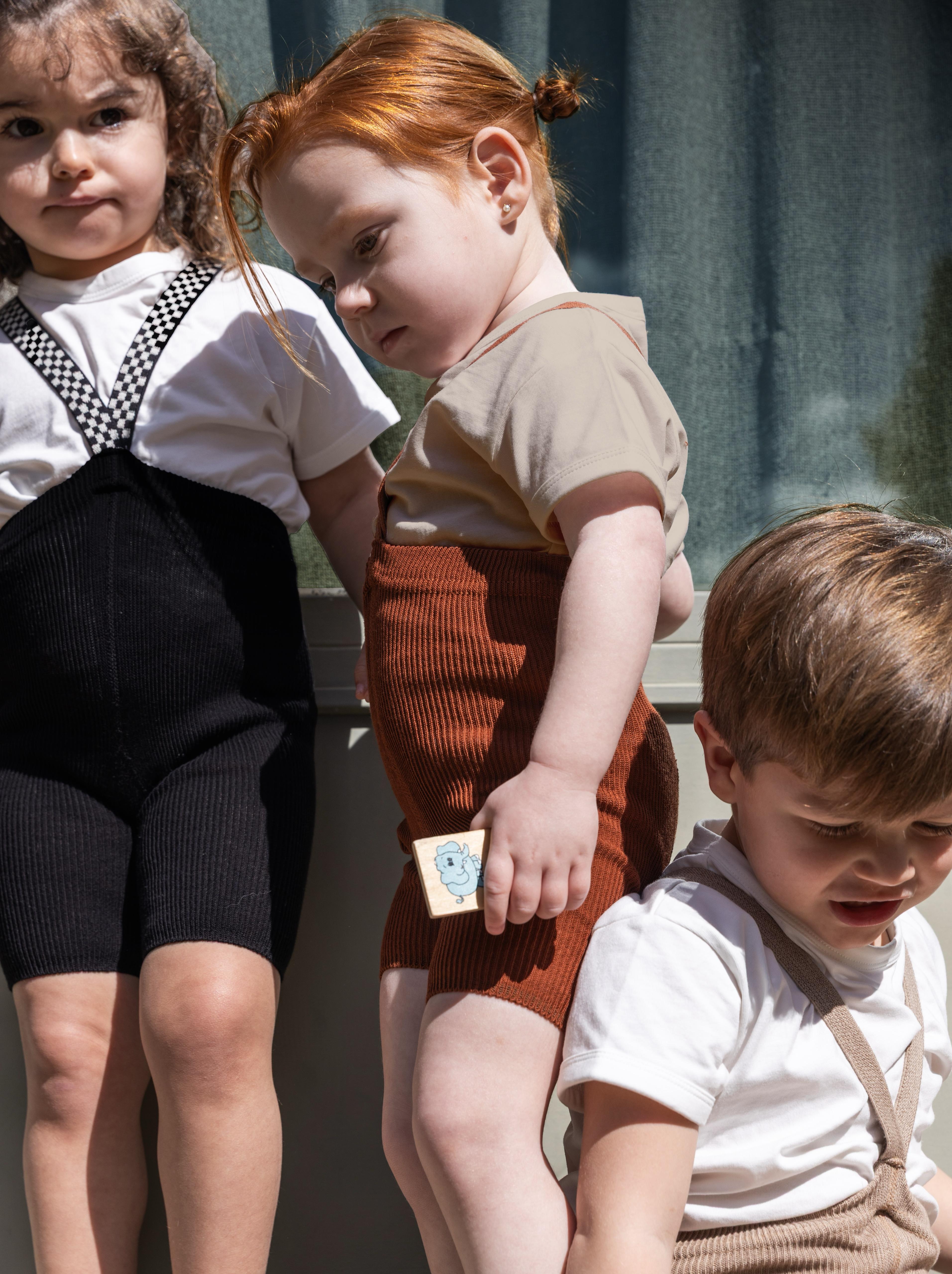 toddlers in organic ribbed cotton cinnamon short tights with braces playing together