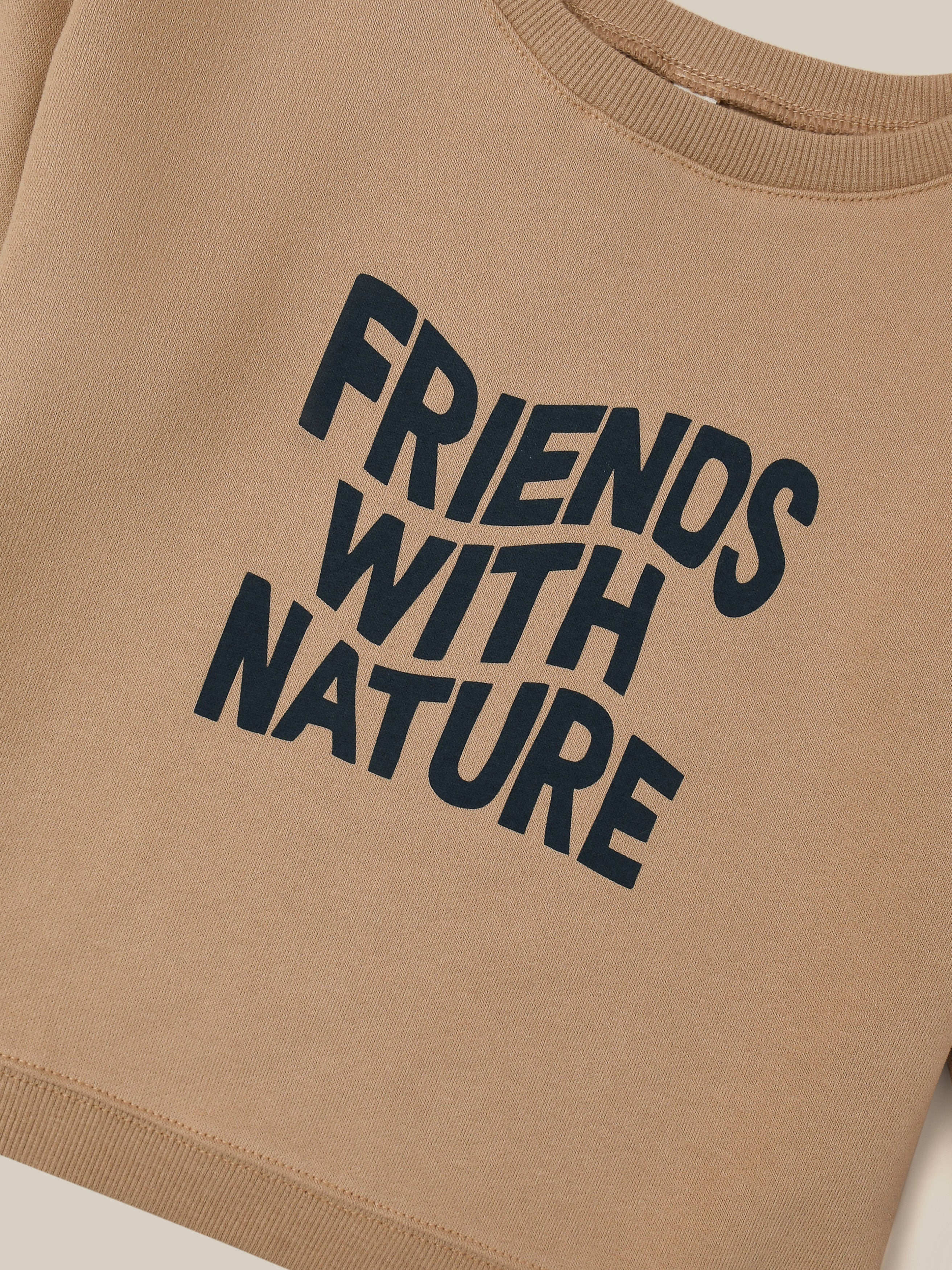 close up of brown sweater with FRIENDS WITH NATURE in wavy text across the front