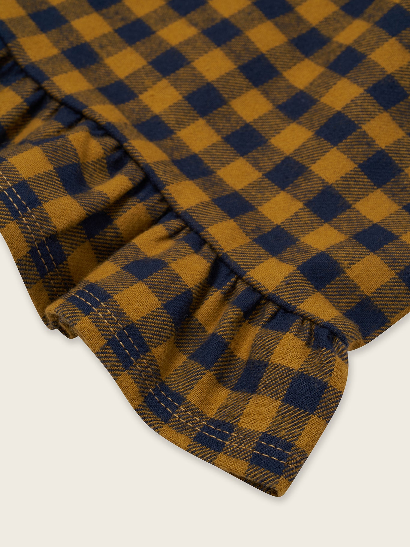 close up of toddler navy and yellow checkered gingham flannel culottes with frill hems