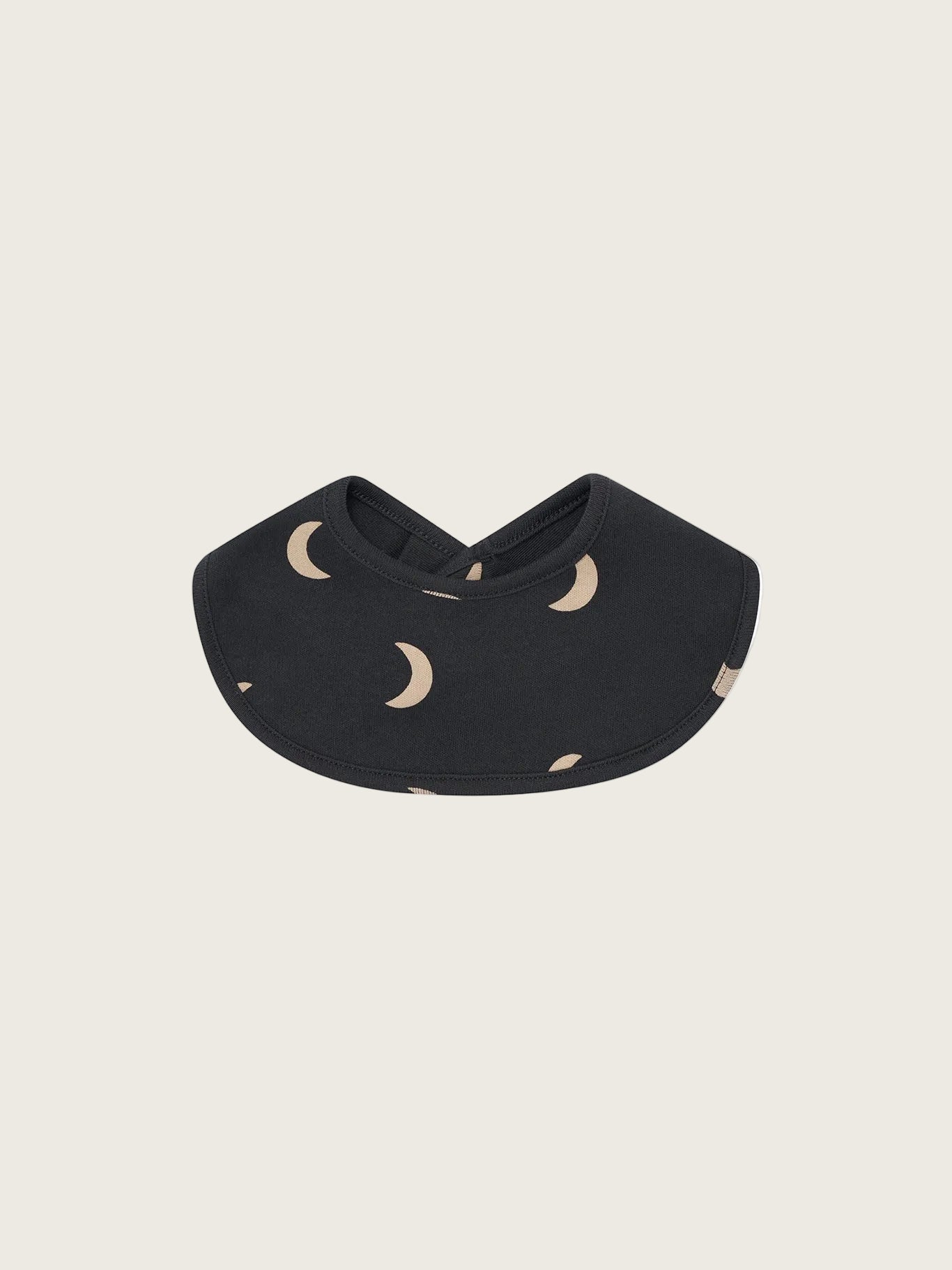 Black bib with beige moon patterns on a white background