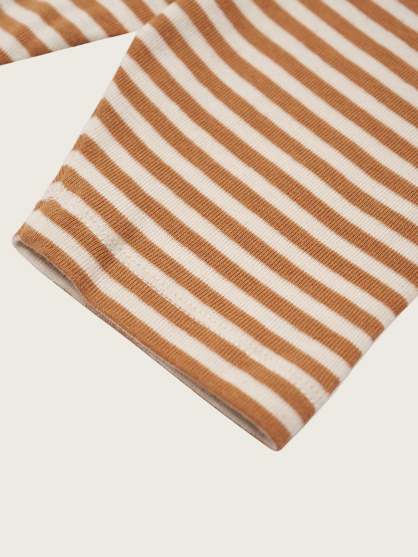 Close-up of a copper and white striped fabric on a white background