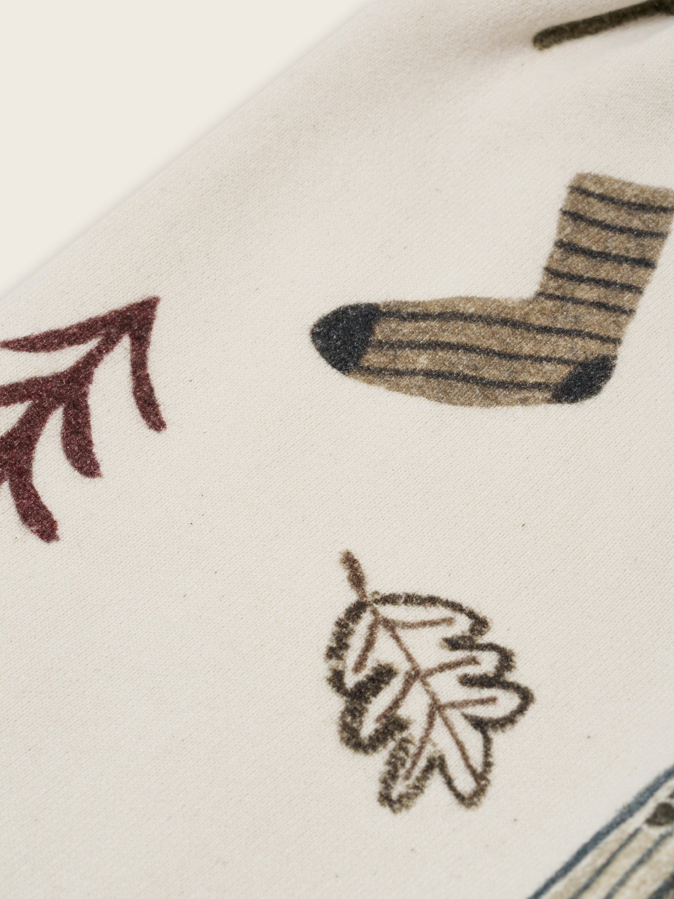 close up of cream undyed cotton wide leg pants with cosy nature-themed graphics