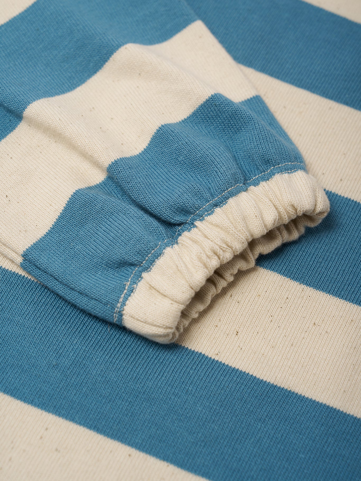 Close-up of a blue and beige striped fabric with ruffled edge