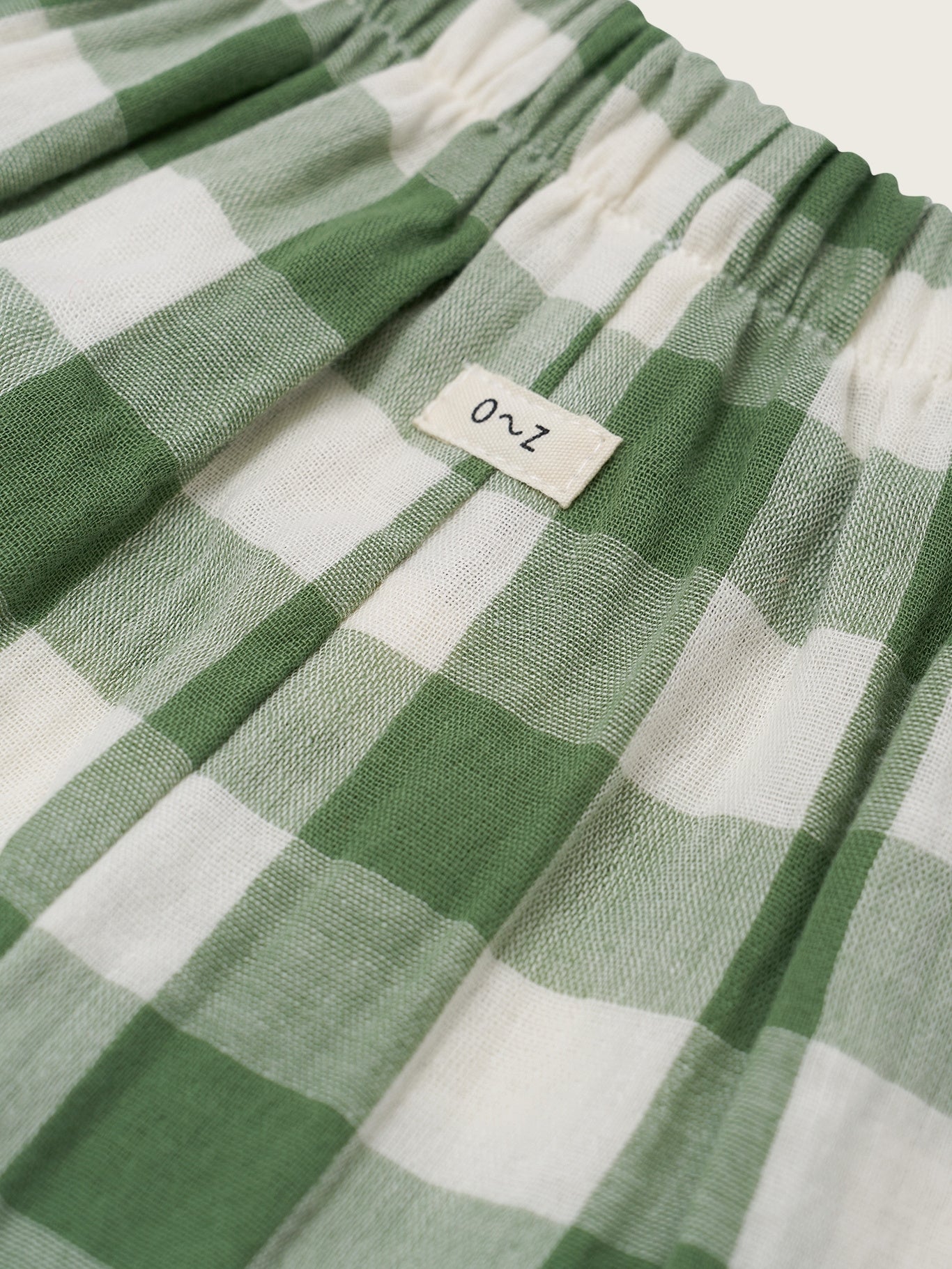 Green and white checkered fabric with a label on a light background