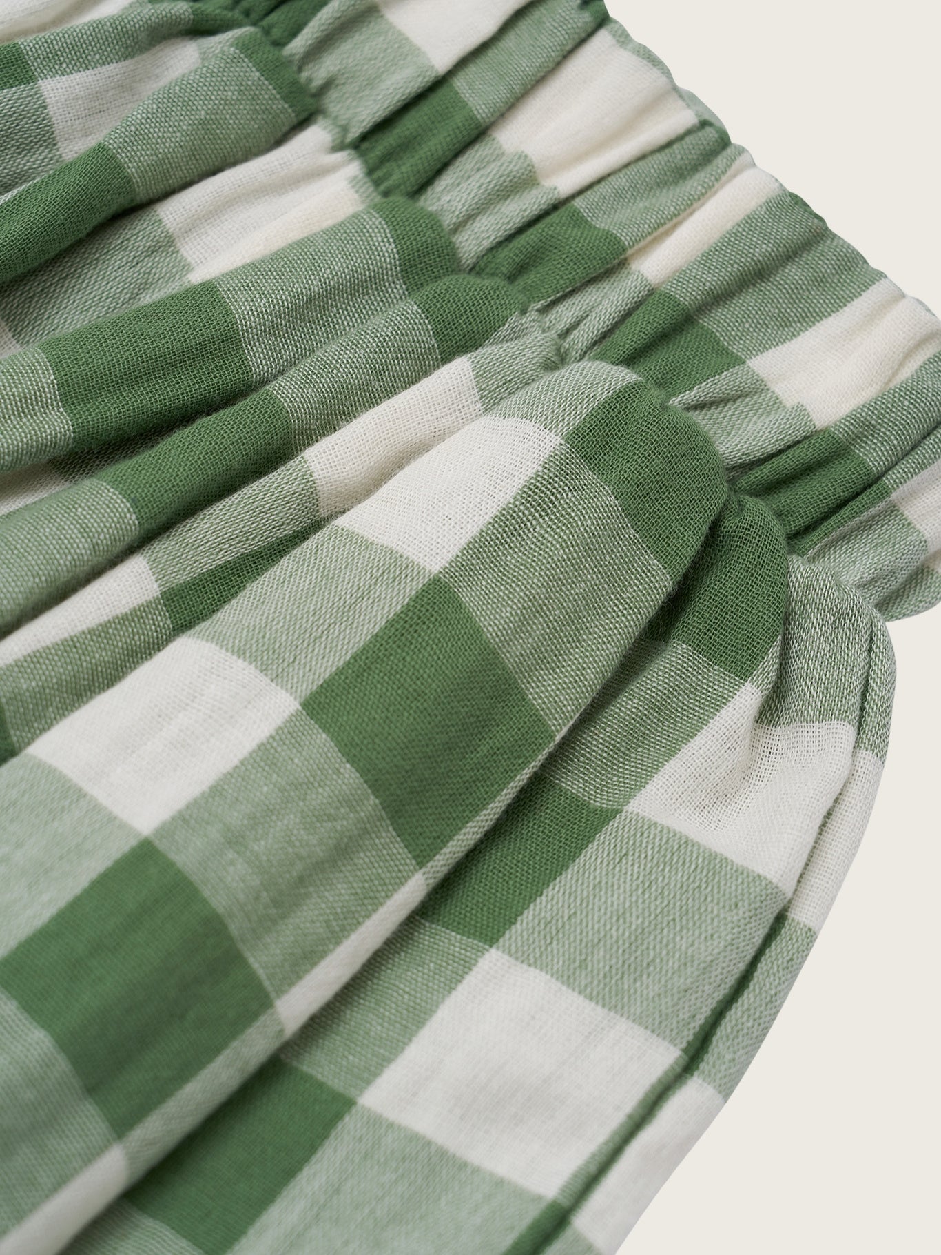 Green and white checkered fabric with a knot on a light background
