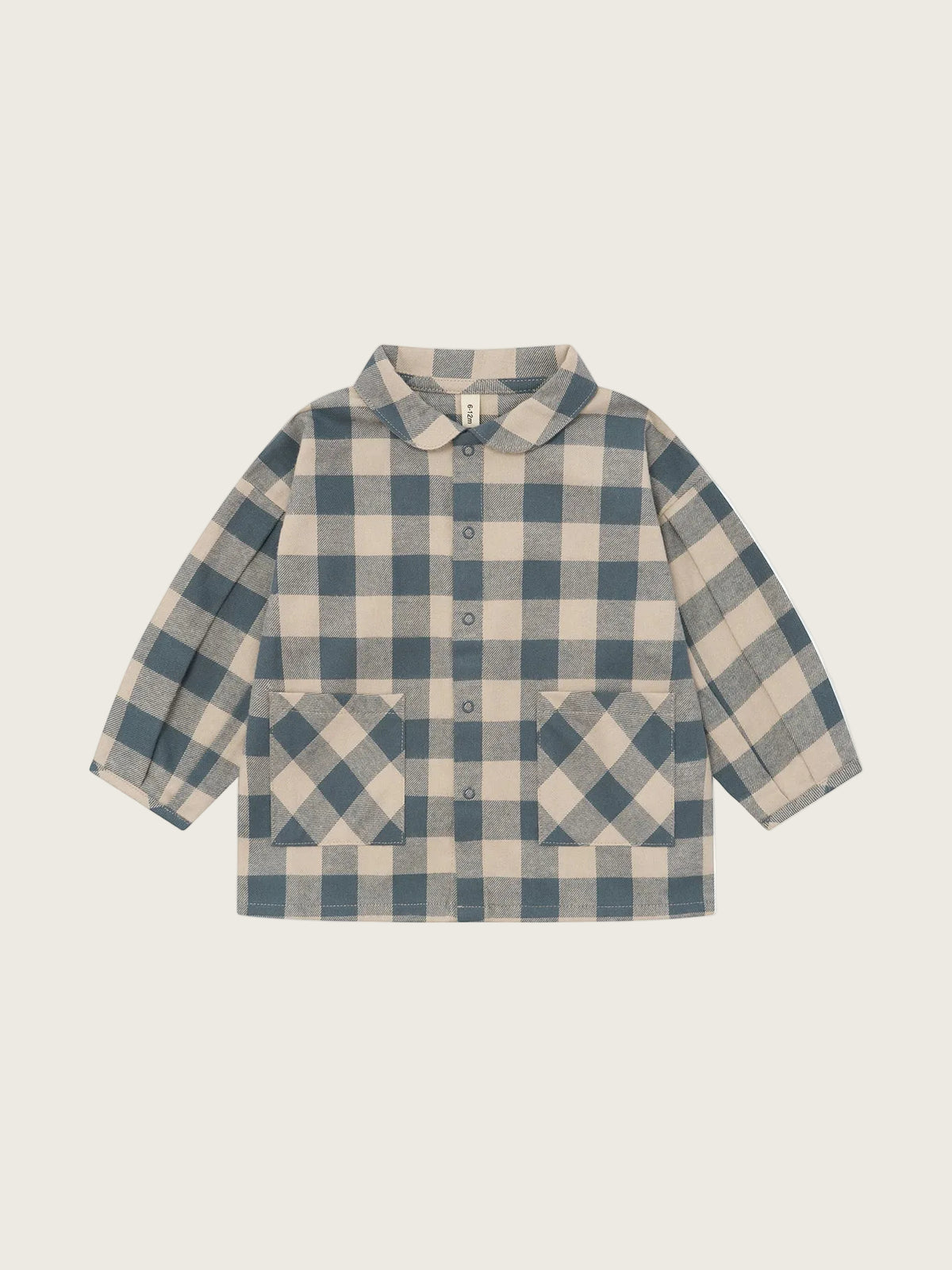 A children's long-sleeve button-front shirt jacket with a blue and beige gingham check pattern, featuring a Peter Pan collar and two front patch pockets, shown flat on a light beige background.