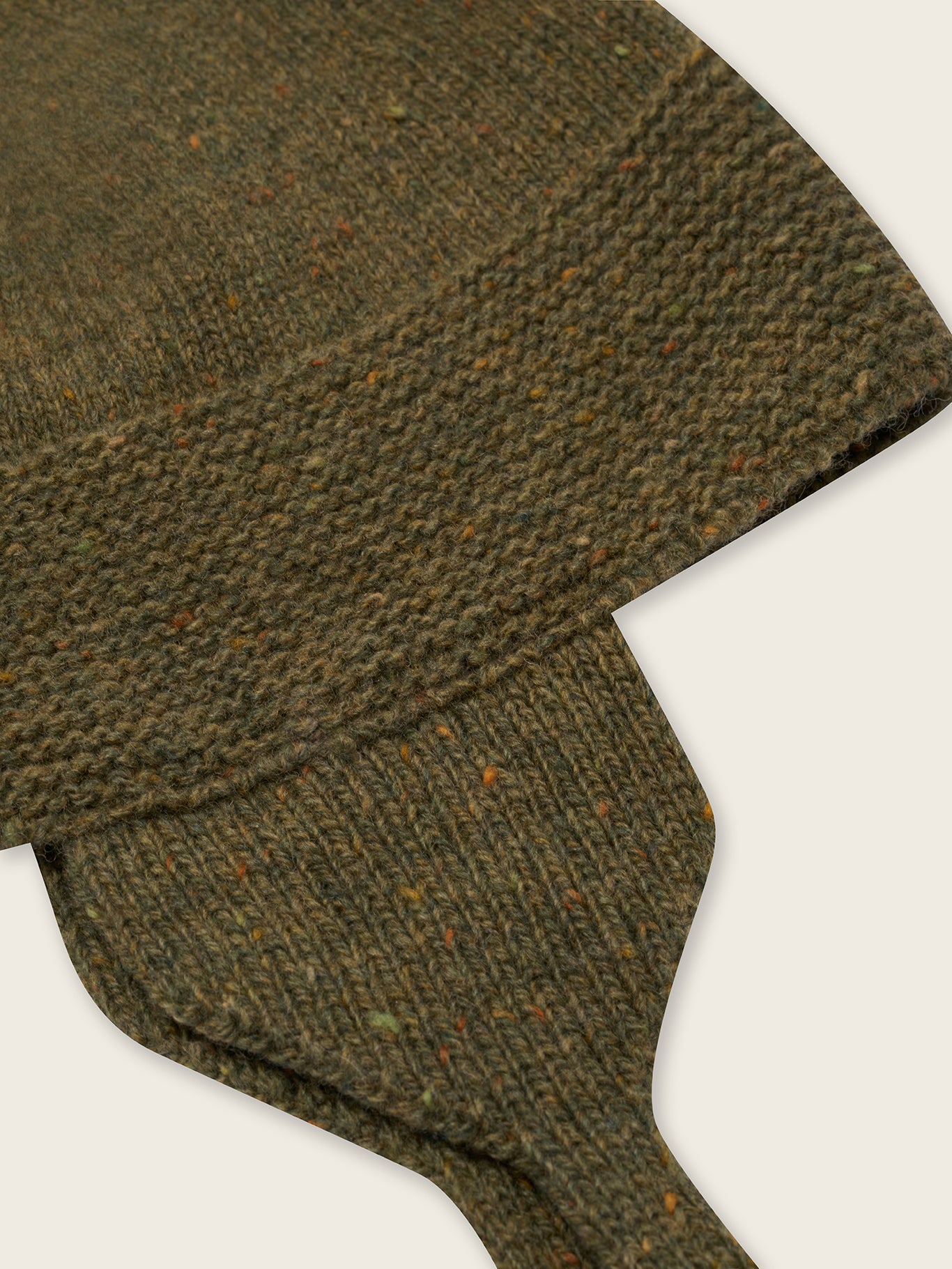 close up of wool hat in forest green with brown tassel and chin tie