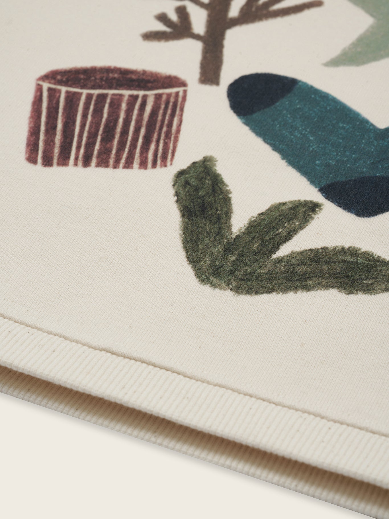close up of cream undyed cotton sweatshirt with nature-themed graphic with socks and tree