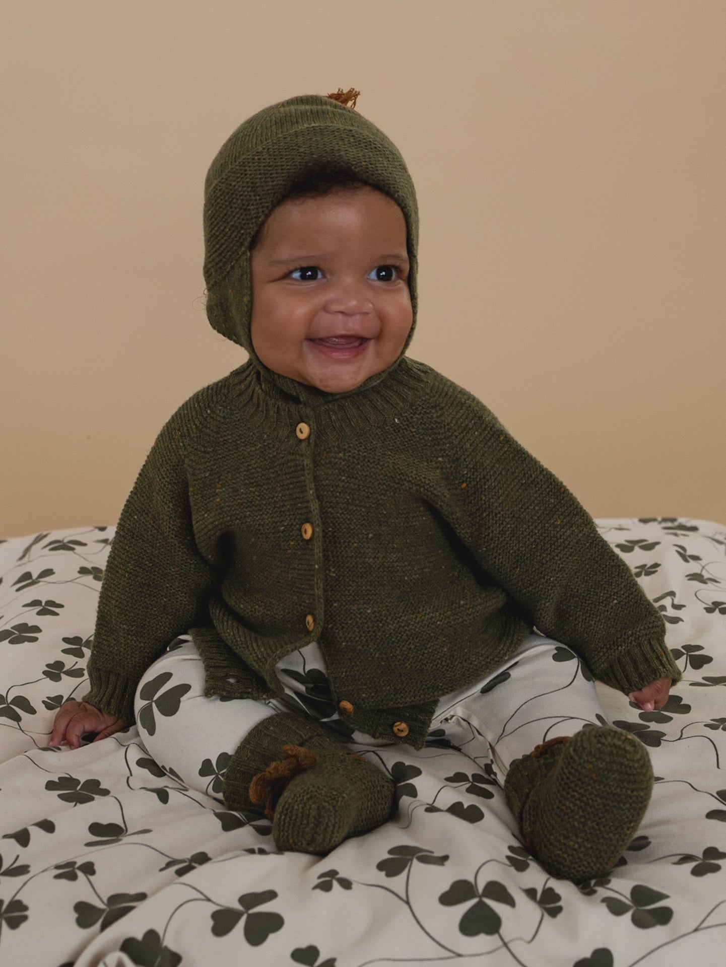 Baby wearing a green knitted outfit