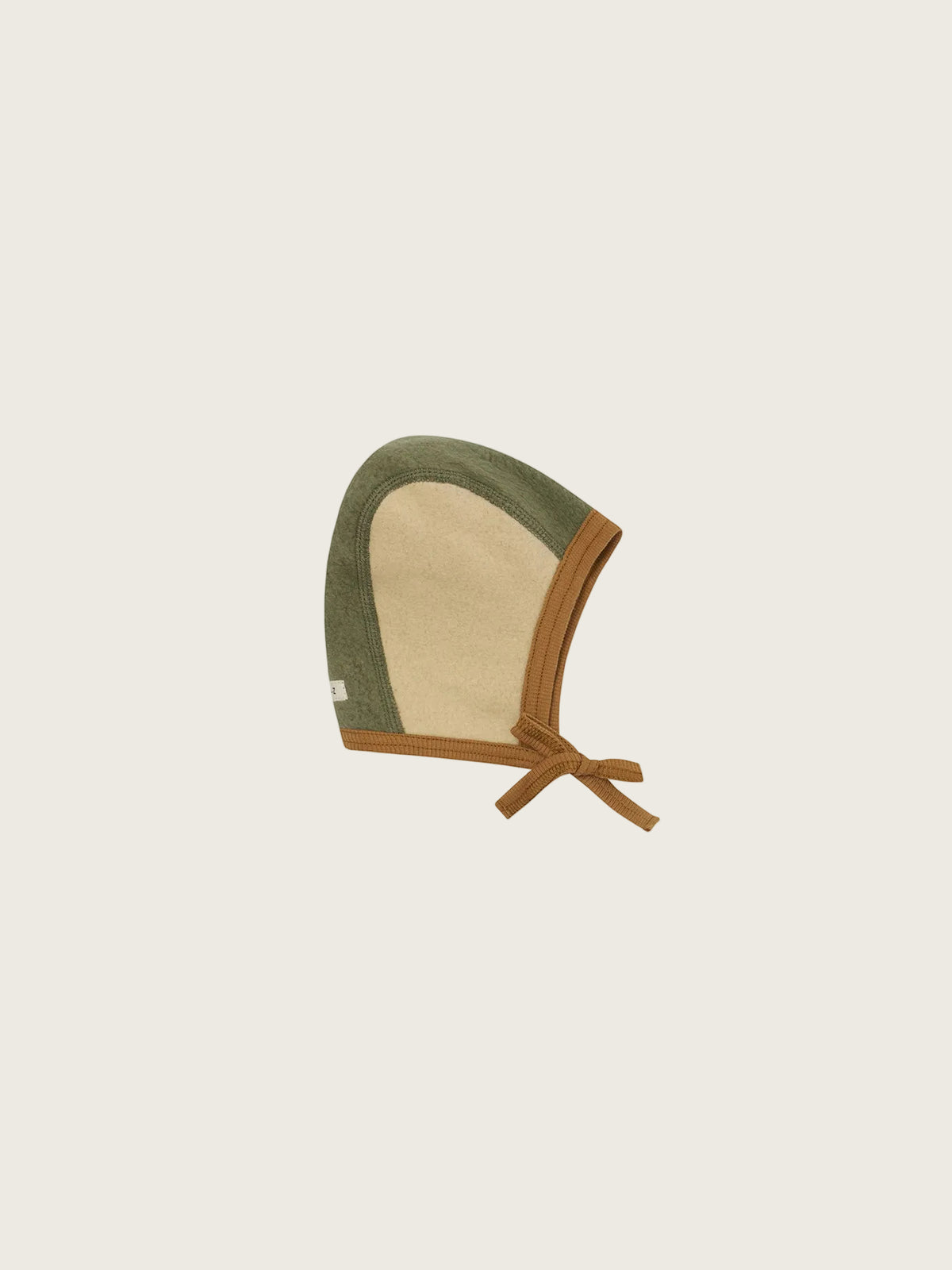 A baby bonnet with an olive green and beige woven fabric body, finished with a brown leather trim and tie straps, shown on a plain white background.