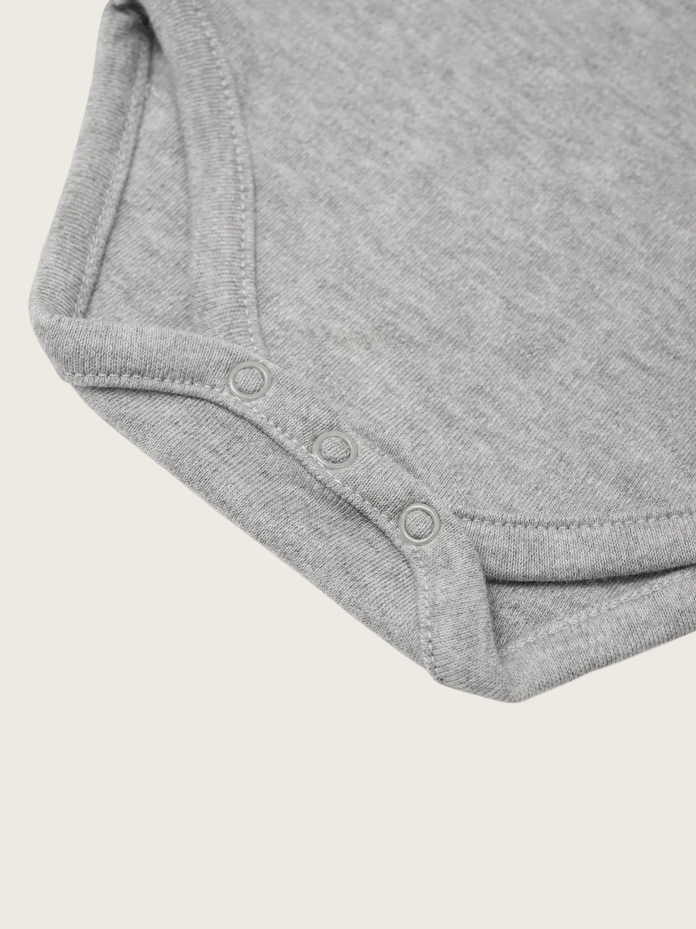 Close-up of a gray baby onesie on a white background