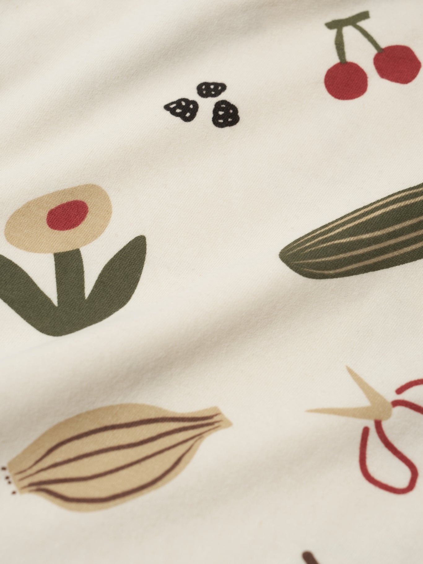 Close-up of fabric with vegetable and fruit pattern on a beige background