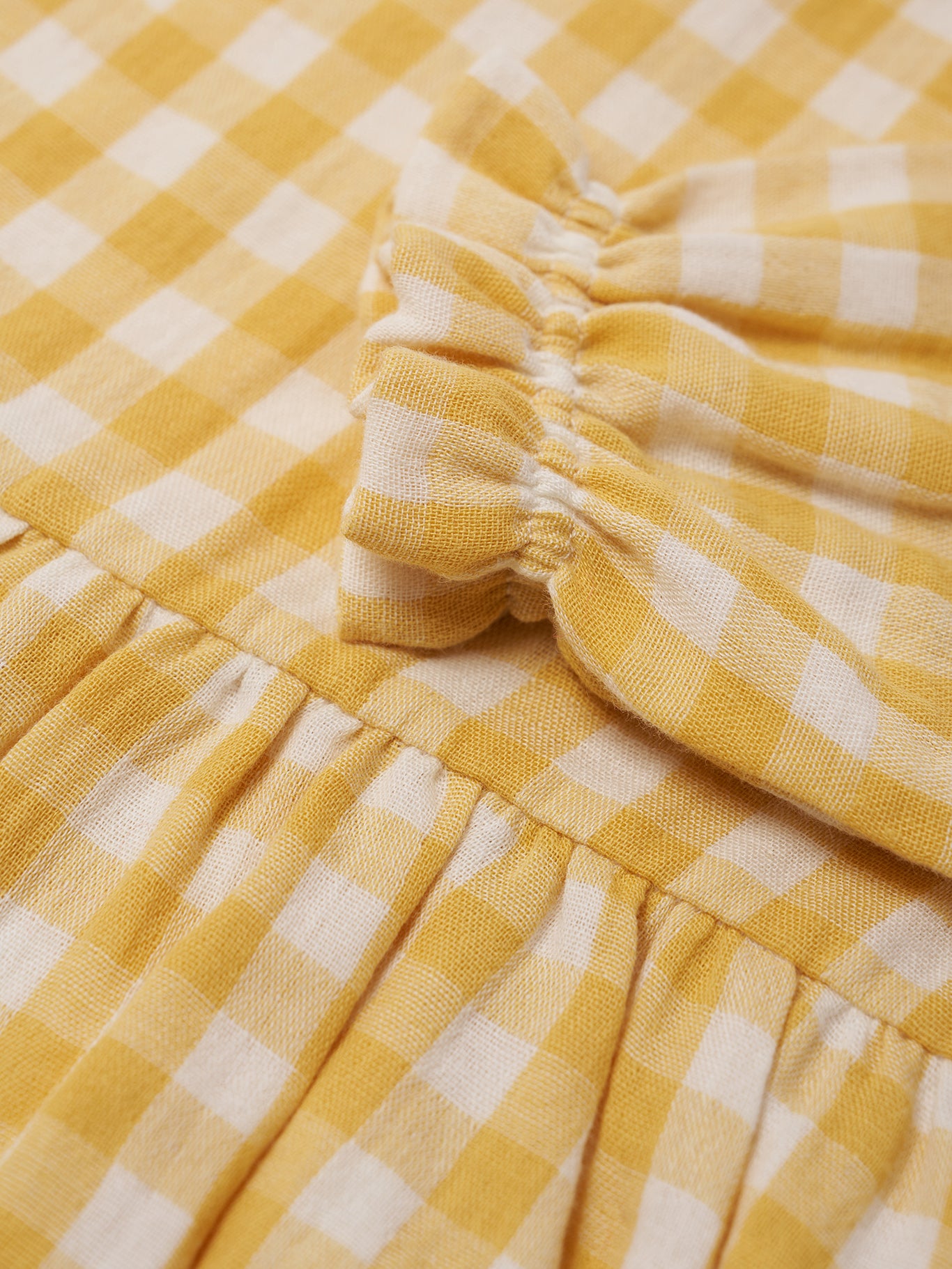 Close-up of a yellow and white checkered fabric with a ruffled edge.