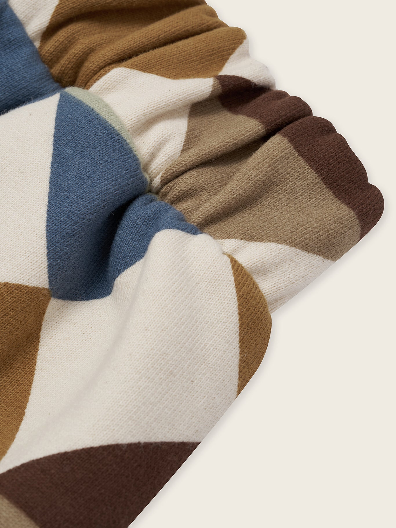 close up of cream undyed cotton pants with multicolour geometric patchwork diamond print