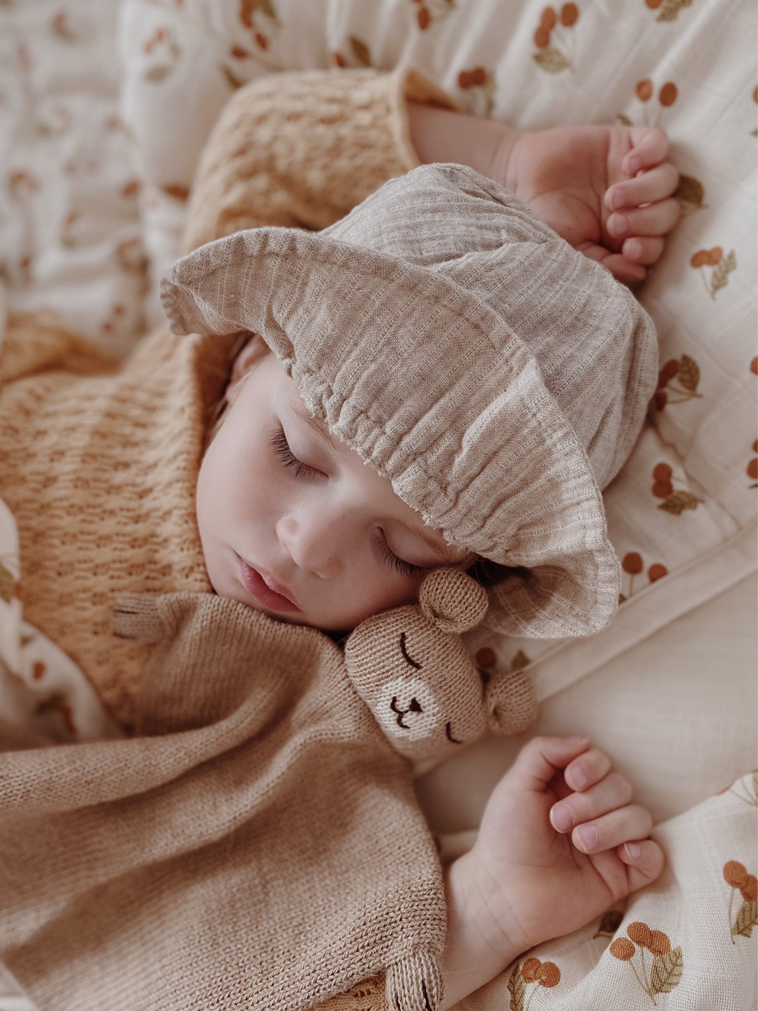 toddler sleeping beside knitted wool teddy cuddle cloth with soft square body and bear head detail