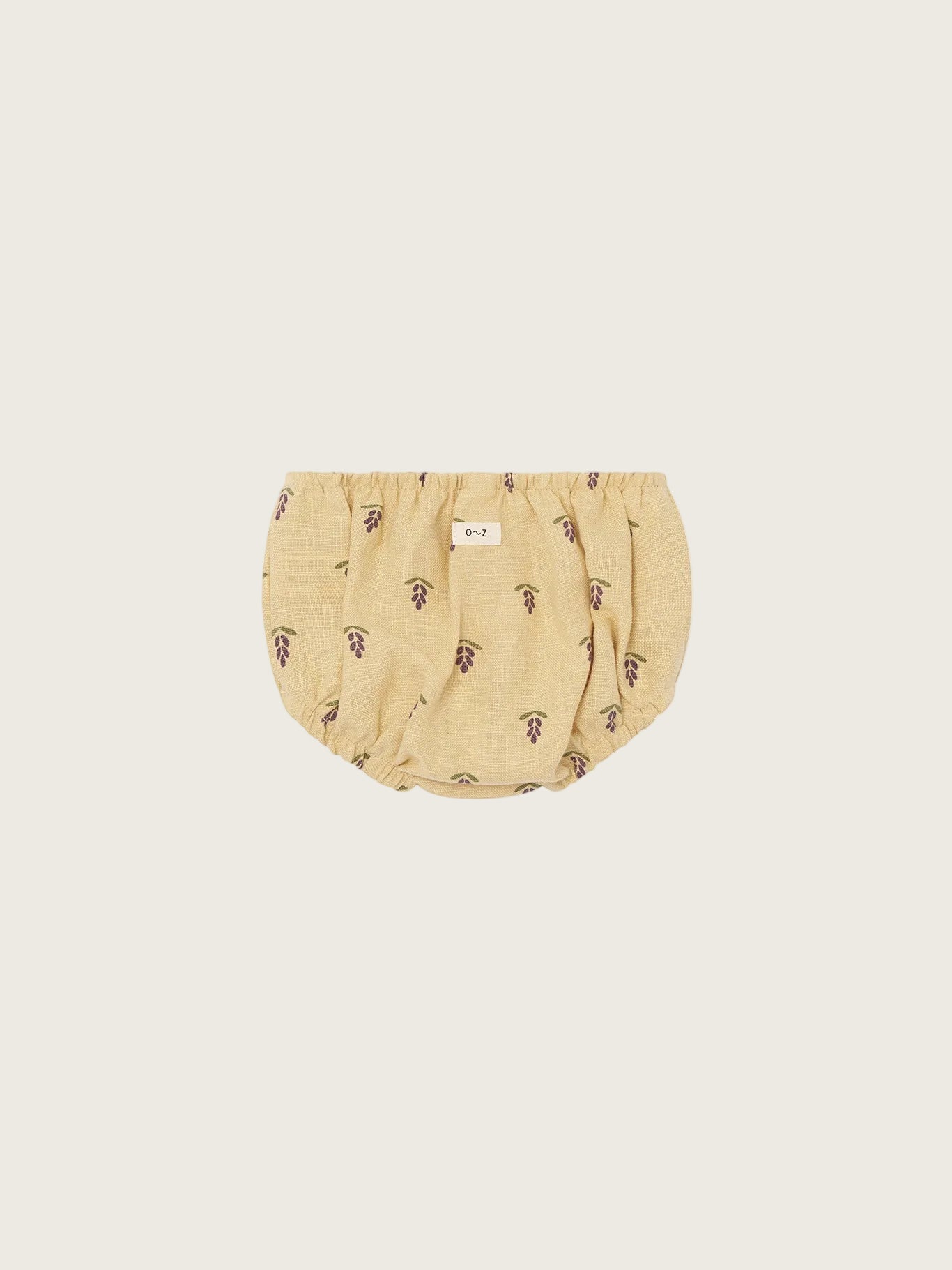 Beige baby shorties with a subtle pattern on a white background