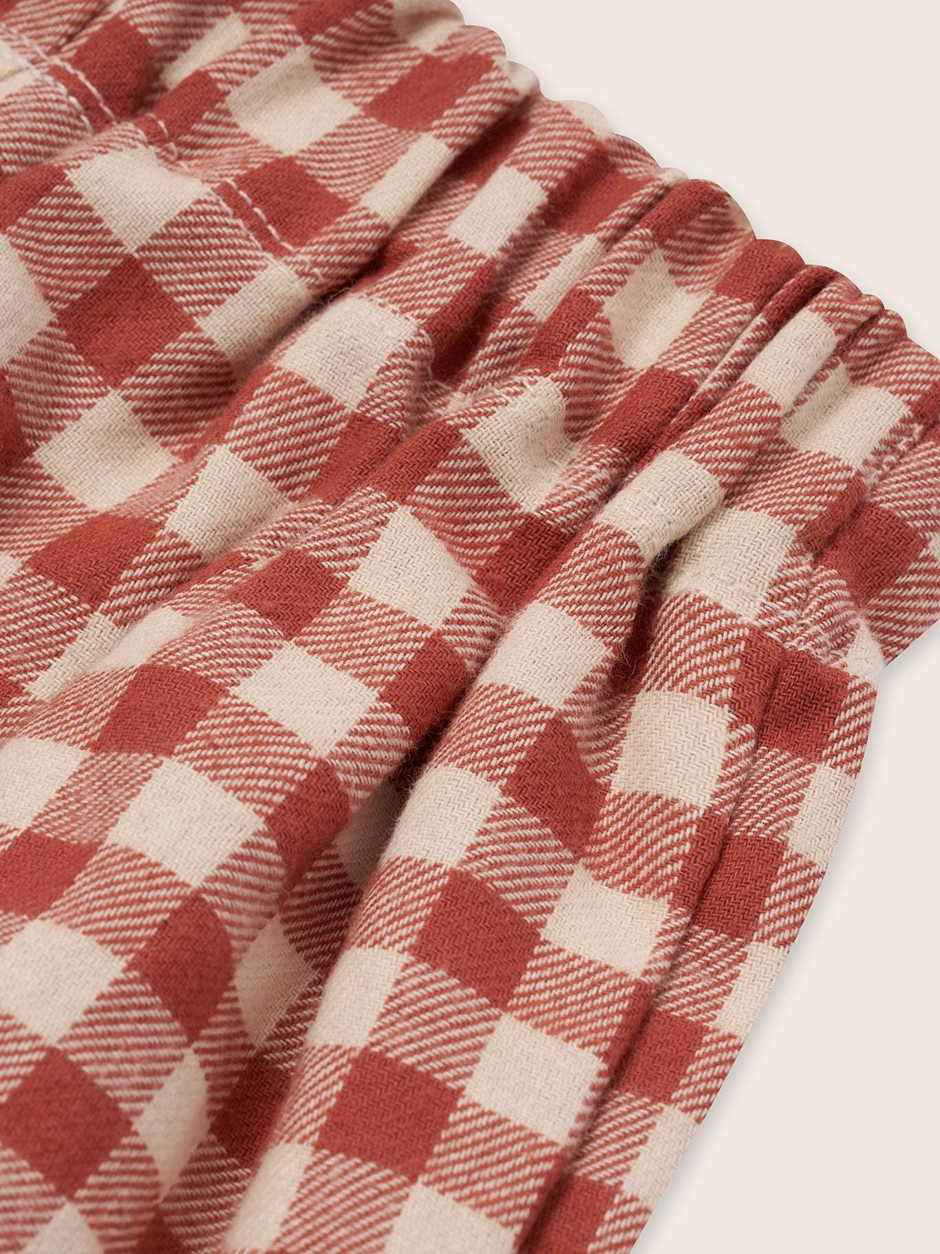 close up of checkered gingham wide leg flannel pants in red and cream