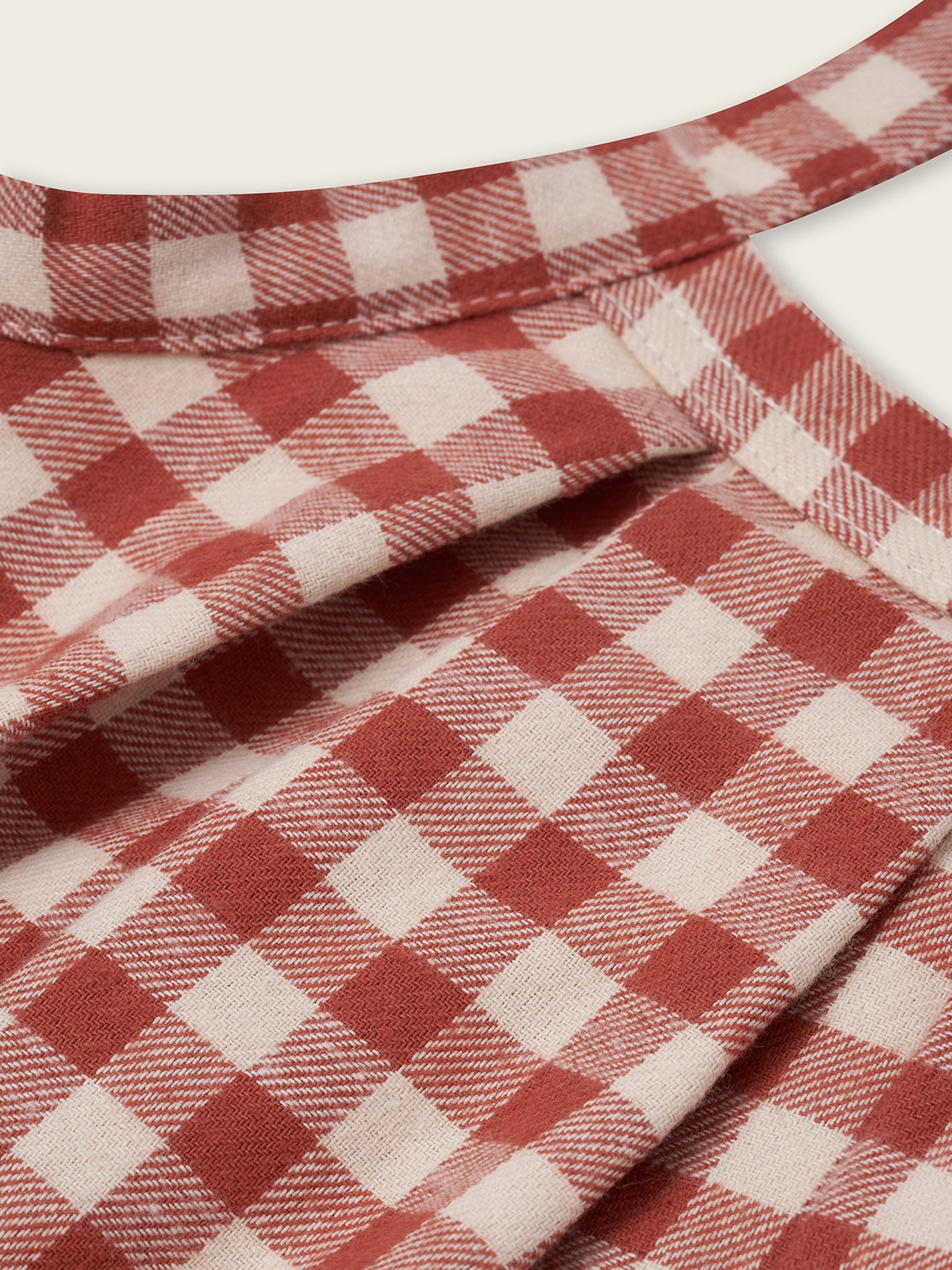 close up of paprika red and cream gingham flannel pleated skirt with adjustable straps