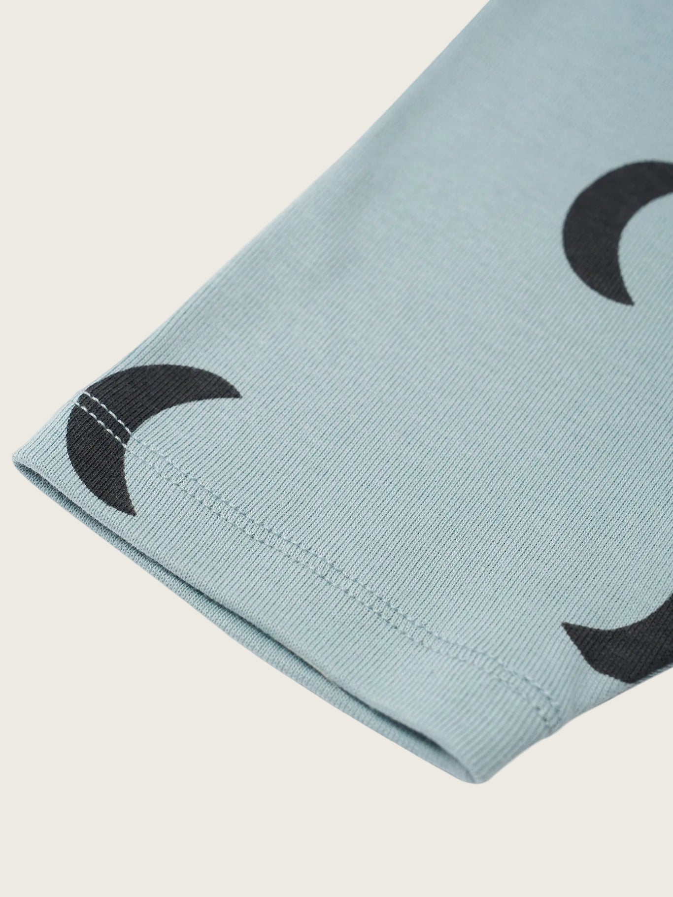 Light blue fabric with black crescent moon patterns on a white background