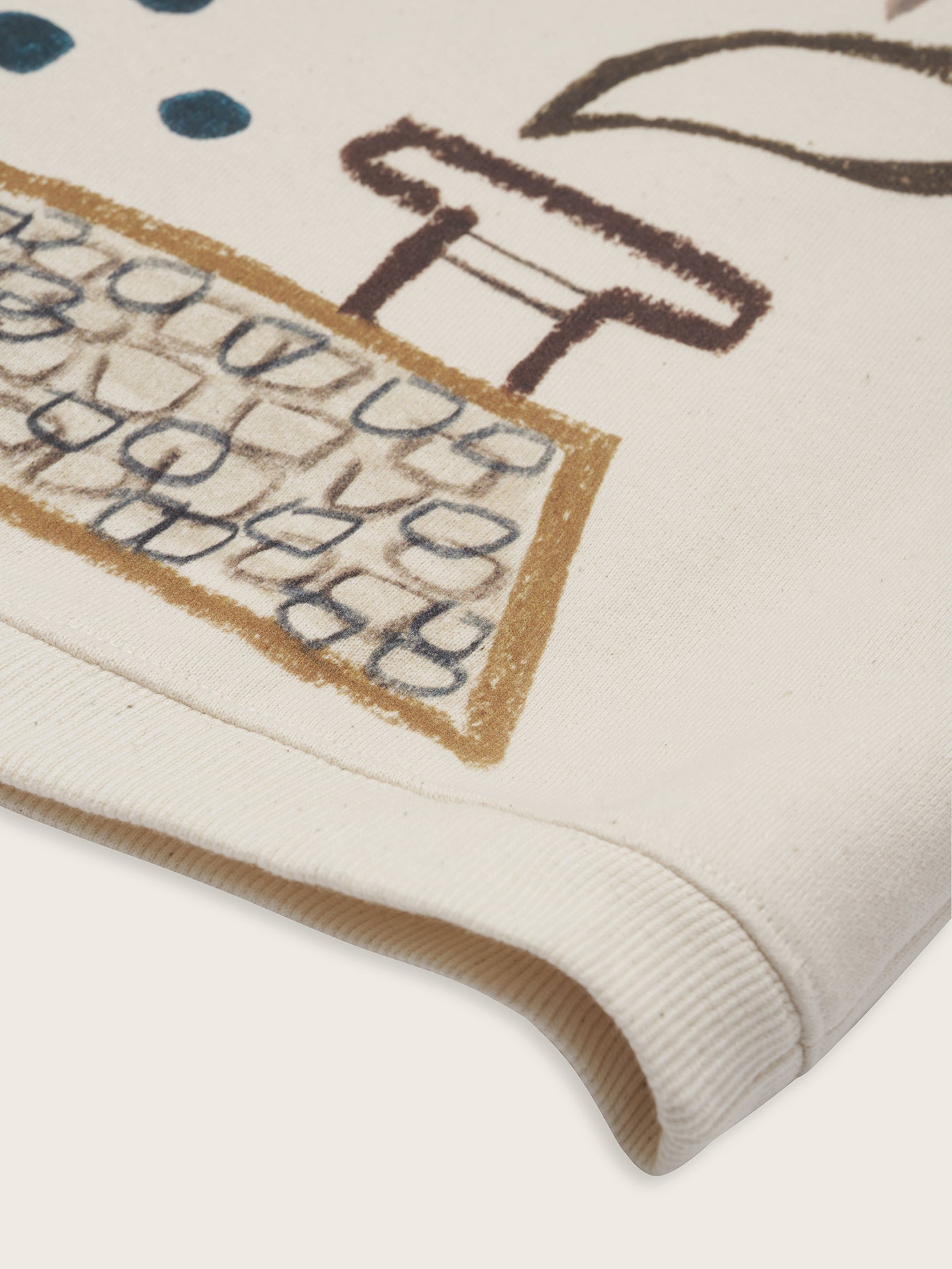 close up of cream sweatshirt with Rooftop Gathering print of birds above rooftop and blue dots