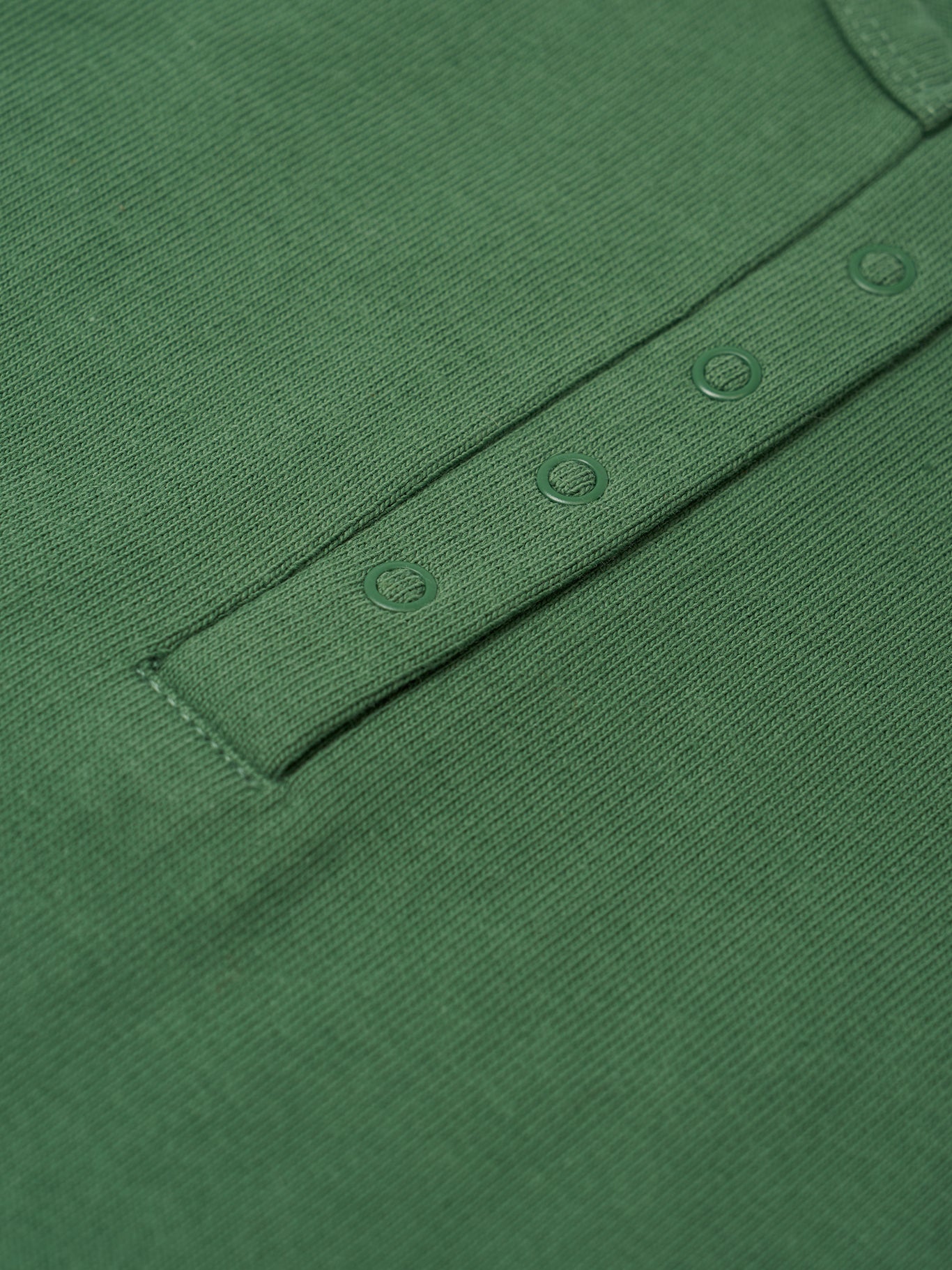 Close-up of a green baby romper with button details