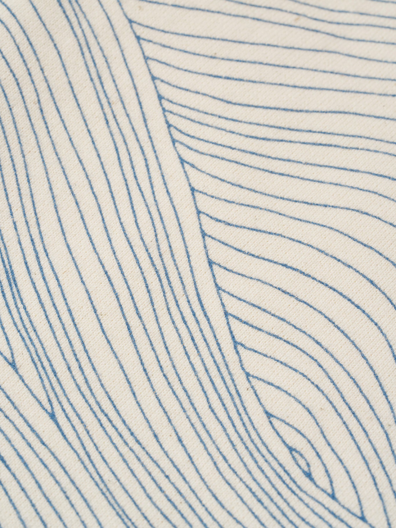 close up of cream undyed cotton wide leg drawstring pants with blue line-drawn ocean waves