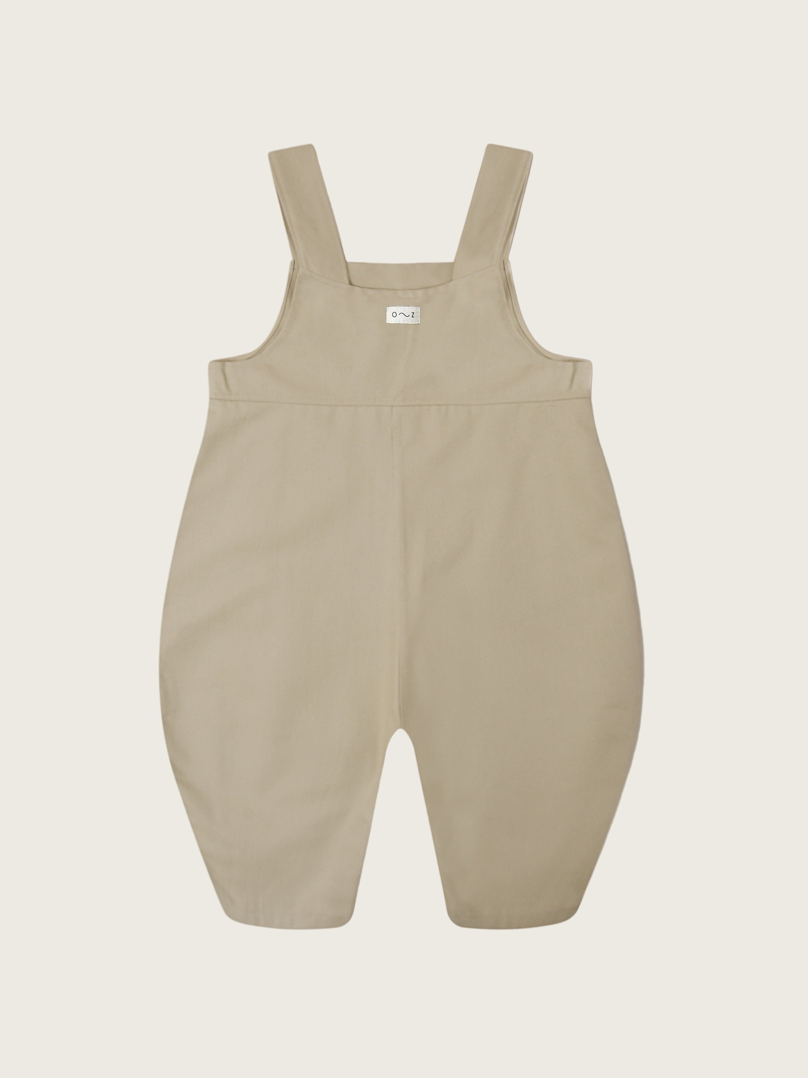 close up of twill cotton oversized farmers dungarees in grey with buttons & side in-seam pockets with gingham finish