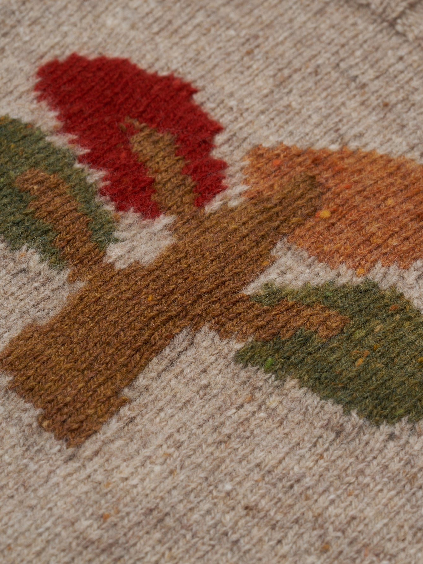 close up of beige wool jumper with square neck, ribbed trim & tree motif in red, orange, green
