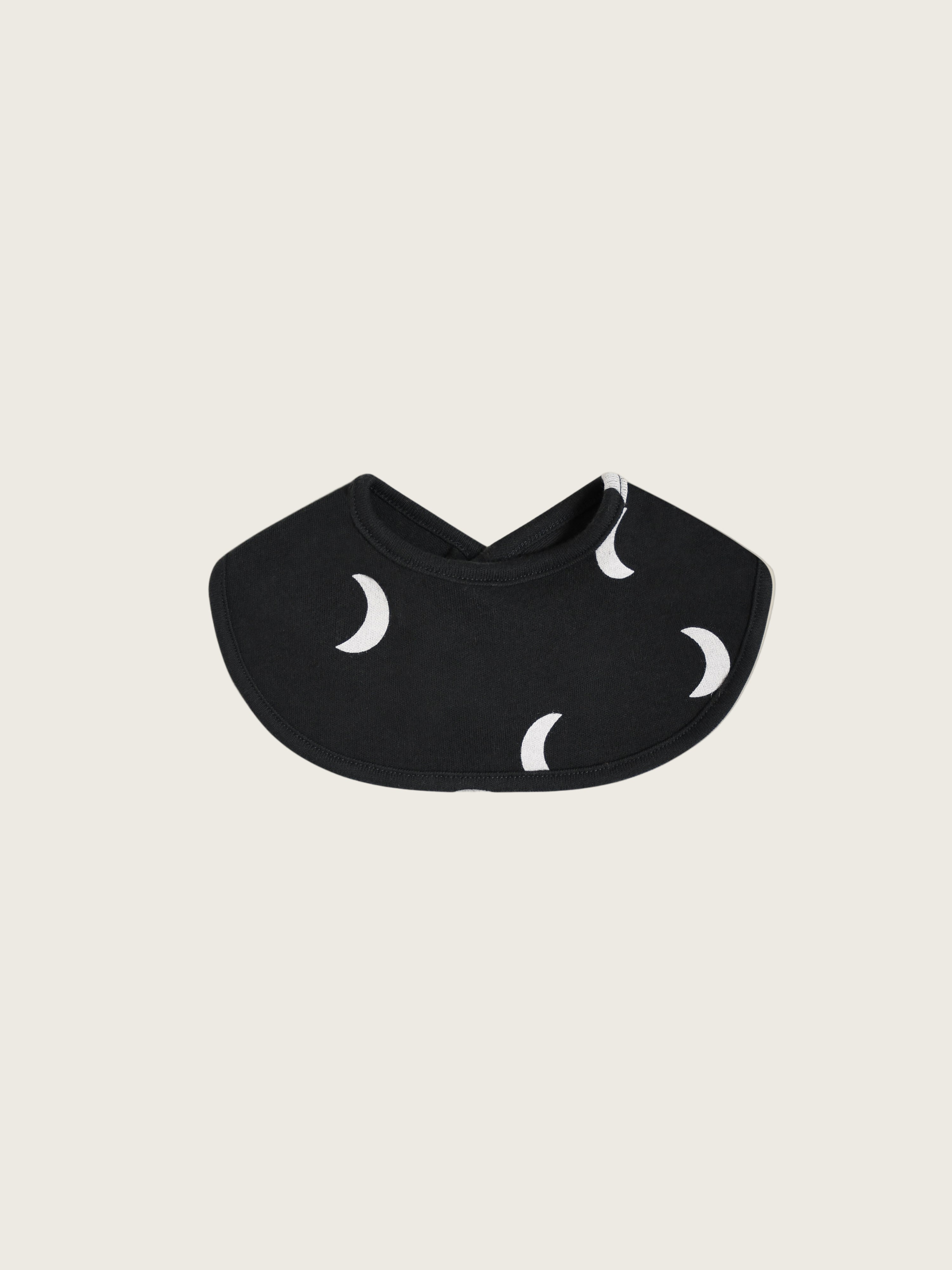 A black baby bib with a moon pattern.