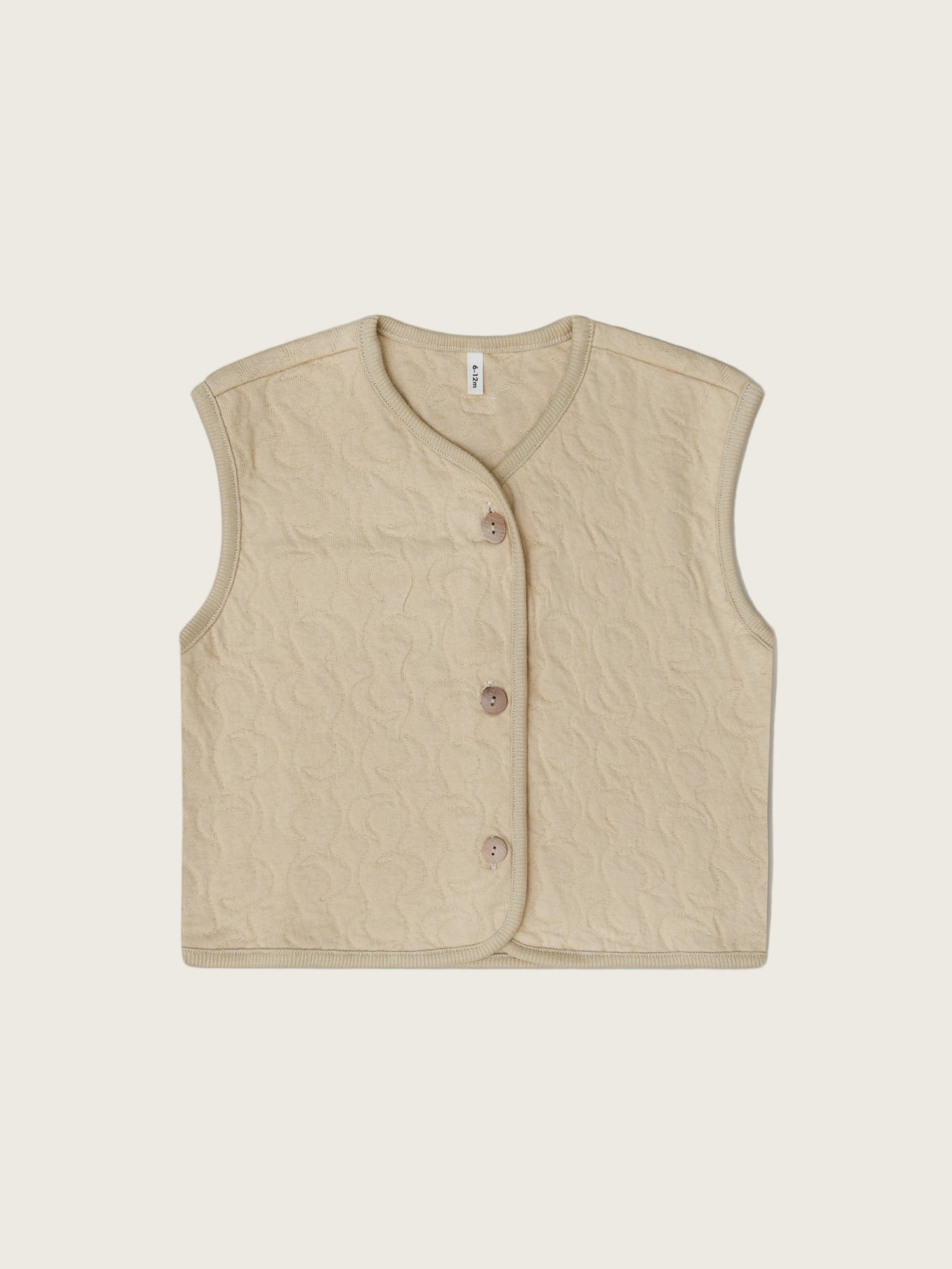 A beige quilted cotton vest with button closures, designed for children.