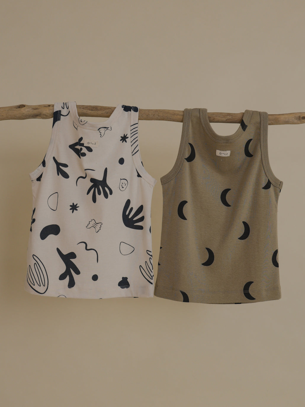toddler summer vests beige black moon print & white navy ocean print hanging side by side on branch