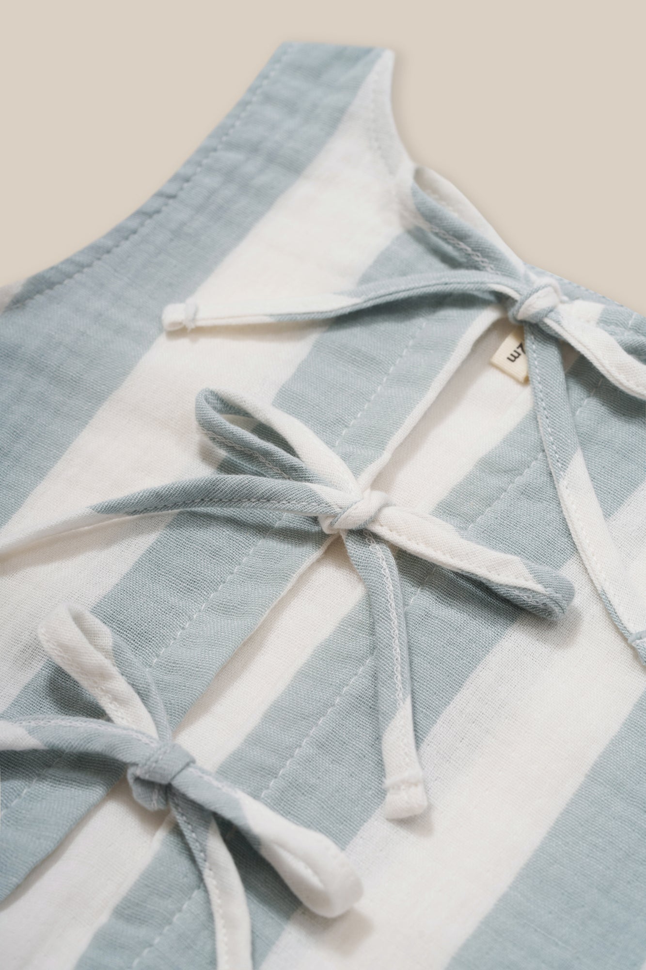 close up of toddler two-way ribbon-tie sleeveless organic muslin resort top in sardine blue and white stripes