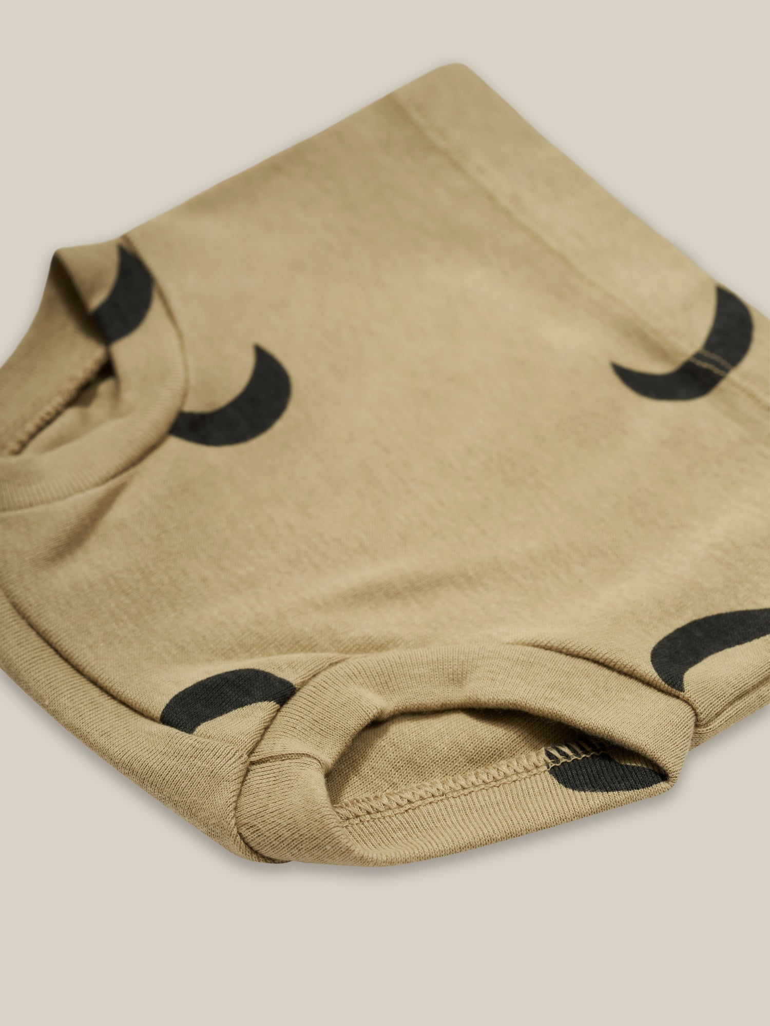 close up of baby & toddler dusky beige organic ribbed cotton shortie with black moon print