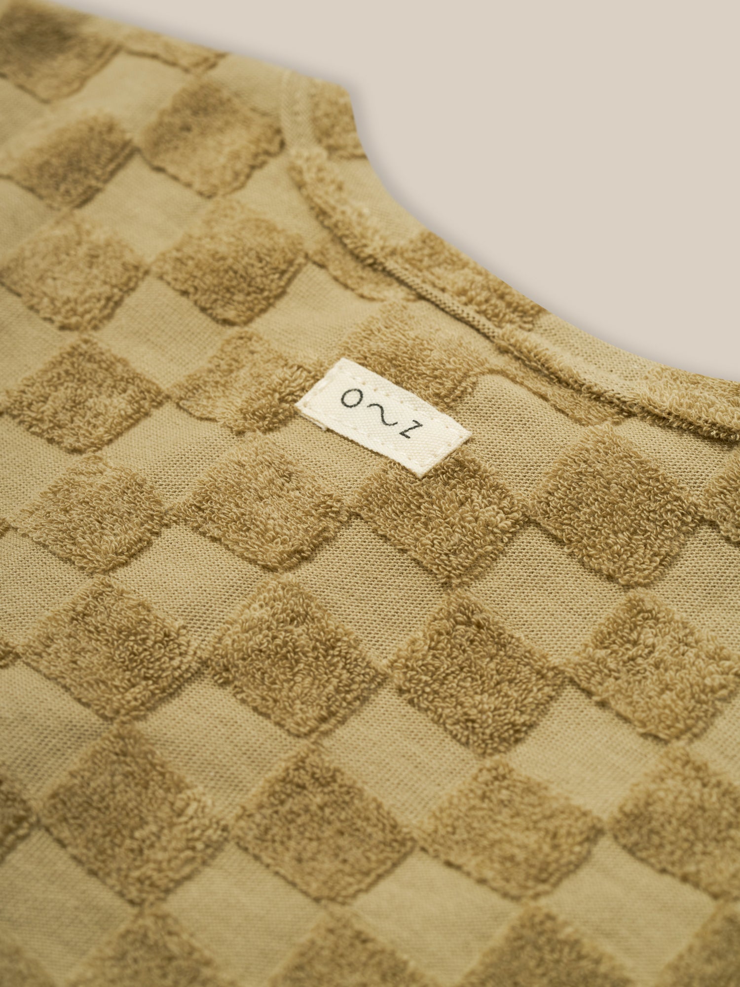 close up of baby & toddler dusky beige checkerboard boxy t-shirt in organic terry cotton