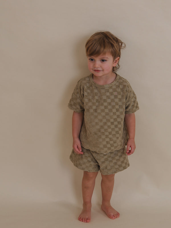 toddler wearing beige checkerboard boxy t-shirt with matching terry cotton shorts