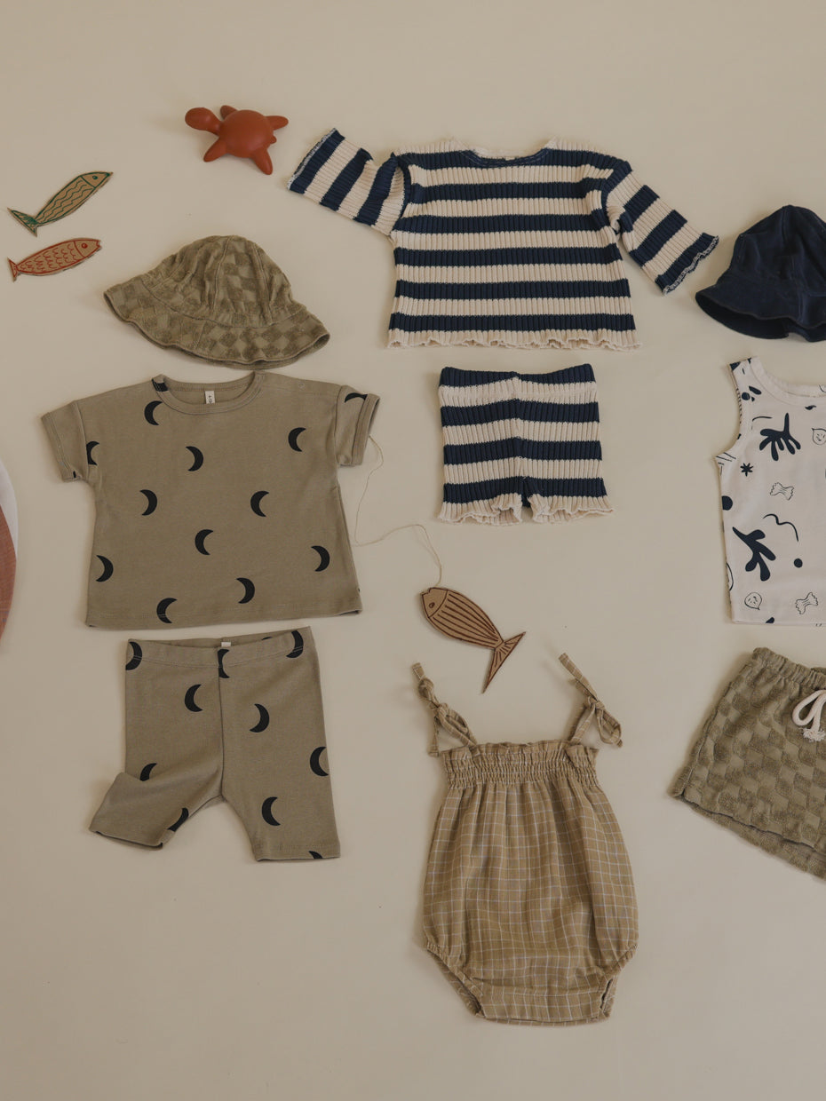 flatlay of outfits including baby gold grid check muslin bodysuit with smocked neckline & spaghetti straps