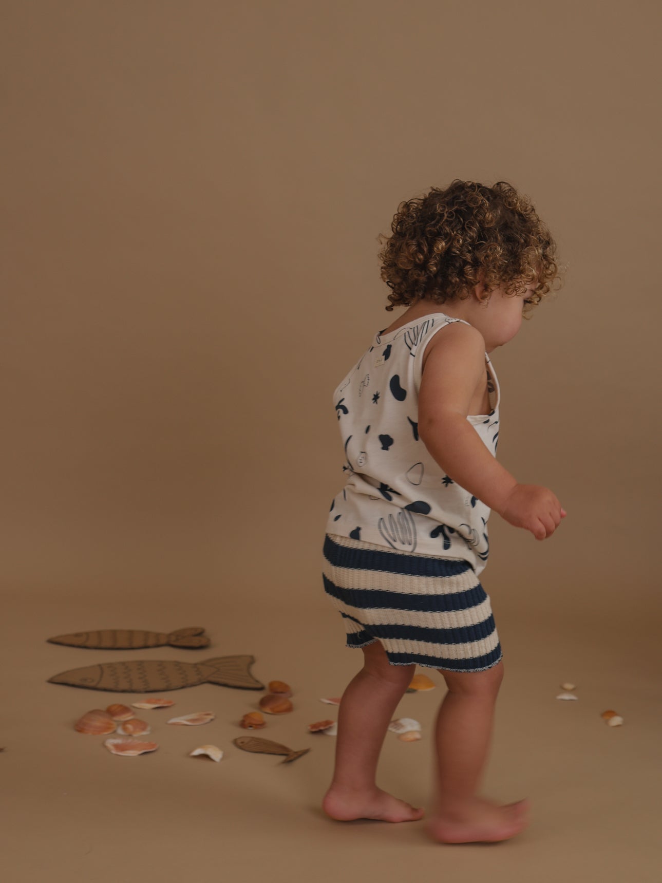 toddler wearing navy striped knitted shorts with summer vest playing