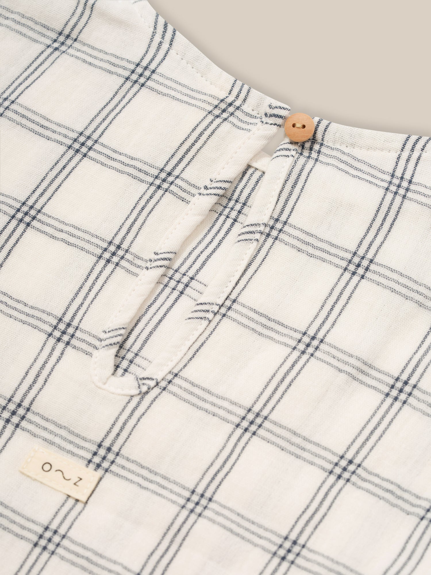 close up of baby & toddler muslin boxy navy window check t-shirt keyhole with button & loop