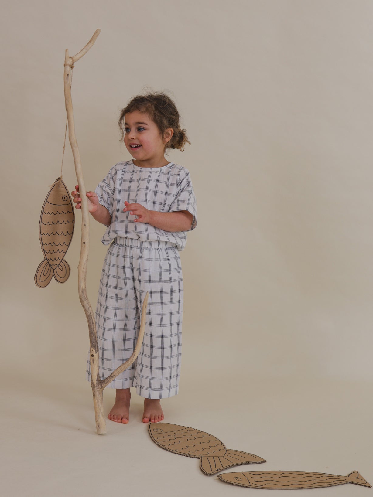toddler in navy window check muslin boxy t-shirt & matching wide leg pants pretend play fishing
