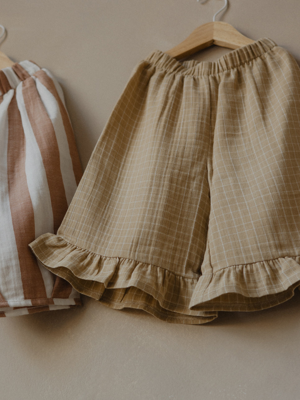 toddler gold muslin culottes with grid check pattern, frill hem & elastic waist on hanger