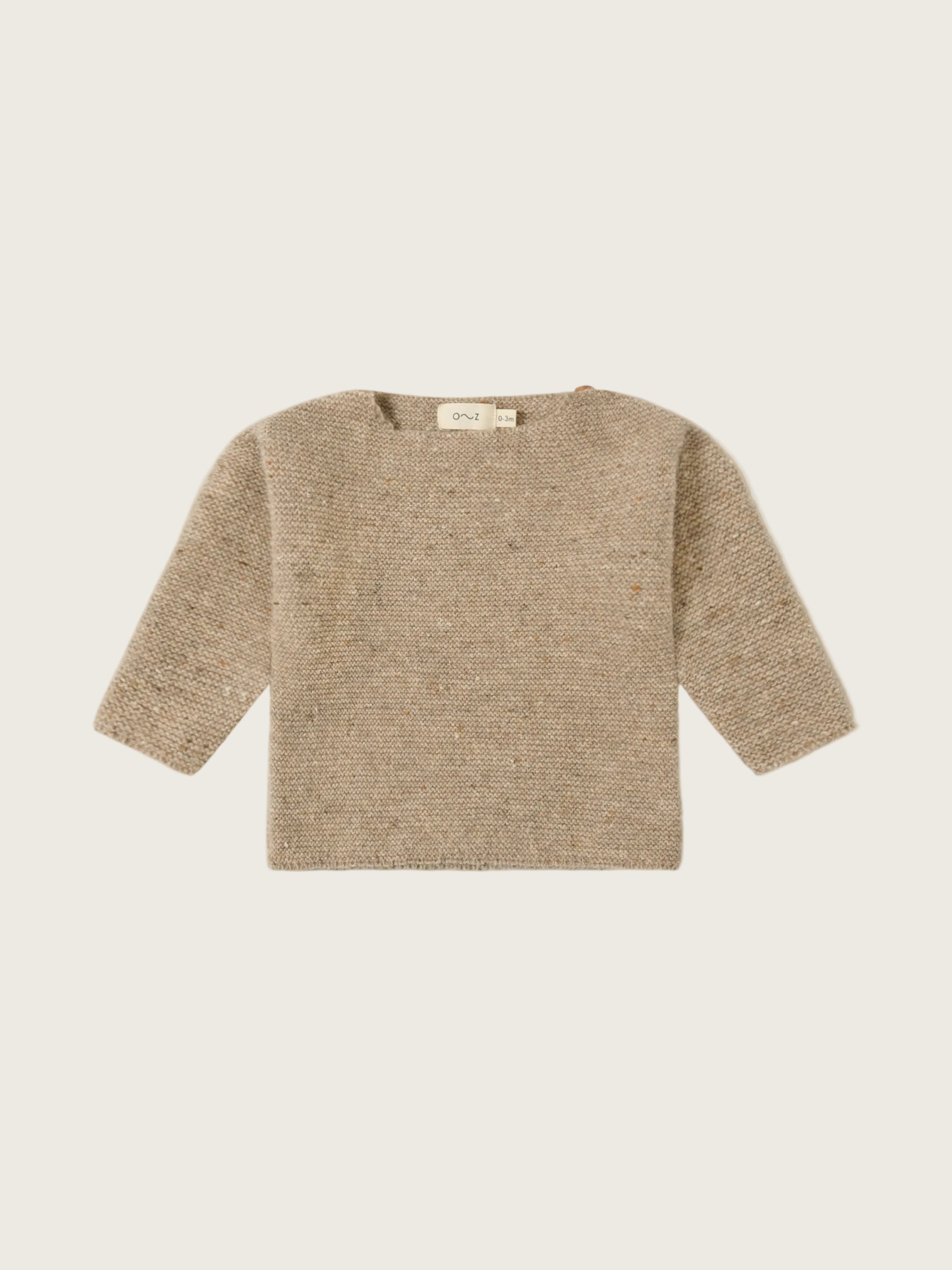 A textured knit long-sleeve sweater in a warm beige/tan color, laid flat against a solid off-white background.
