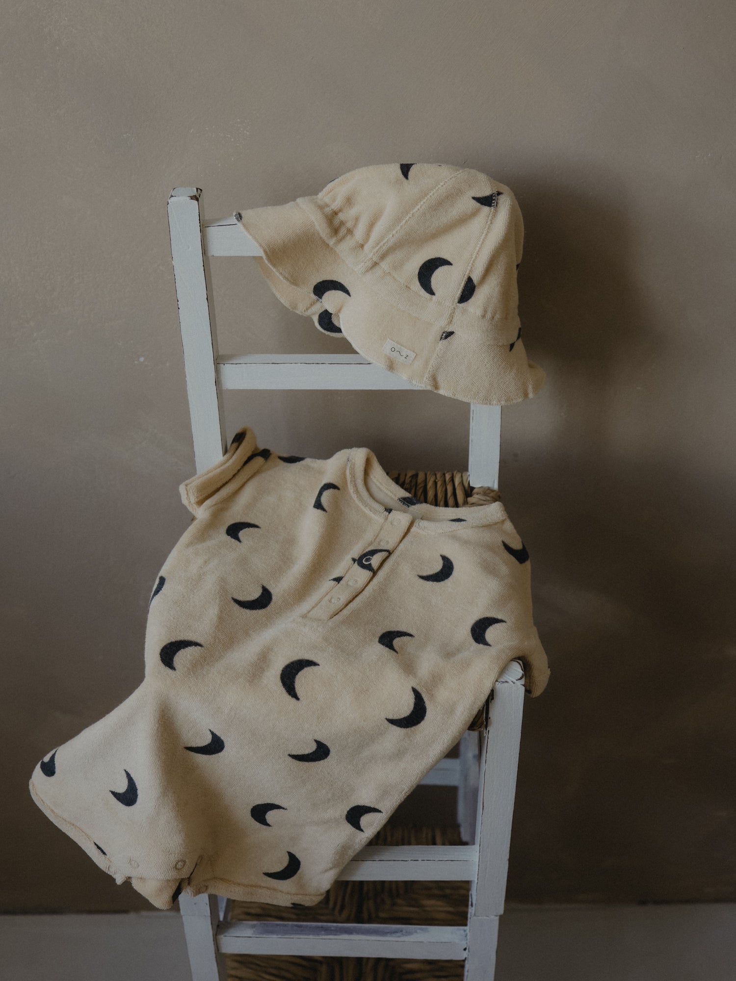 pebble midnight terry sun hat and romper on the chair