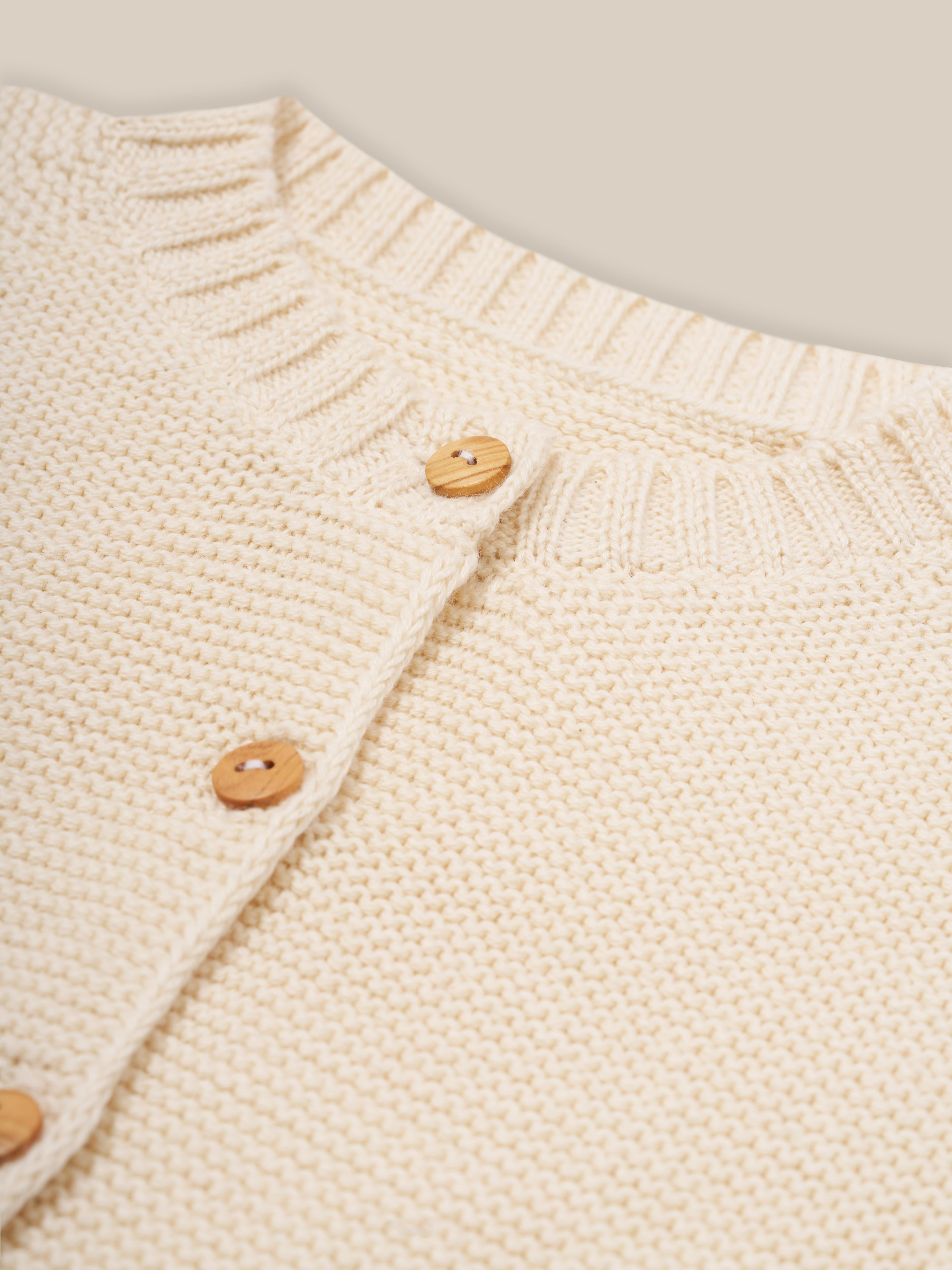close up of button down undyed cotton knitted cardigan in cream